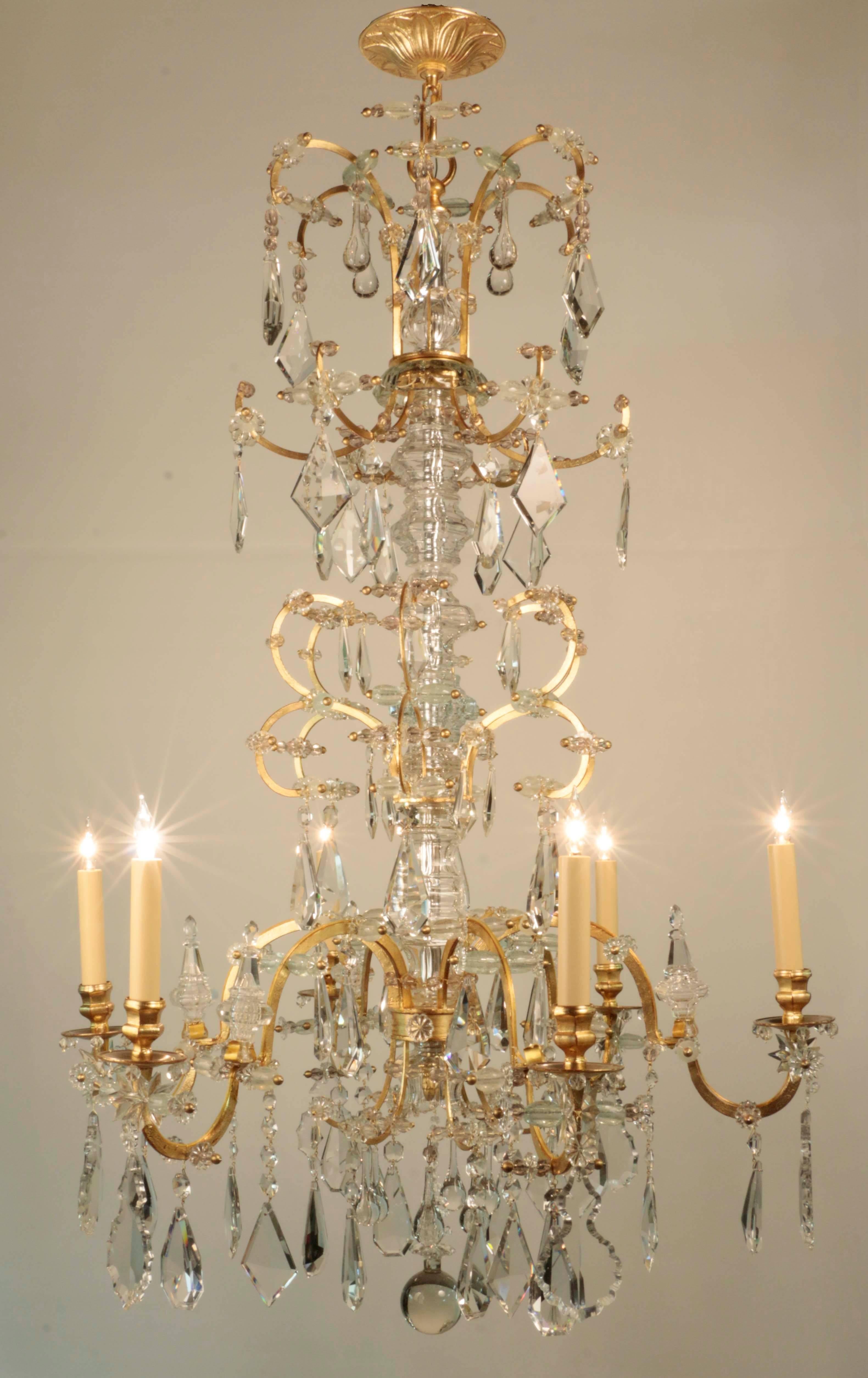 A rare pair of large French 19th century chandeliers. Each with six lights, the gilded shaped arms applied with opalescent beads, the central columns clad in shaped glass sleeves, the whole hung with drops and violin shaped crystals, with gilt