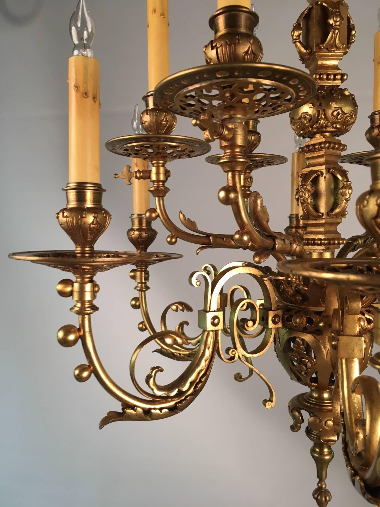 An antique twelve-light neo-Renaissance gilt bronze chandelier, the arms modeled with scrolling acanthus, the drip pans and central spherical globes pierced. This fixture was originally a gasolier which dates it approximately to the last half of the