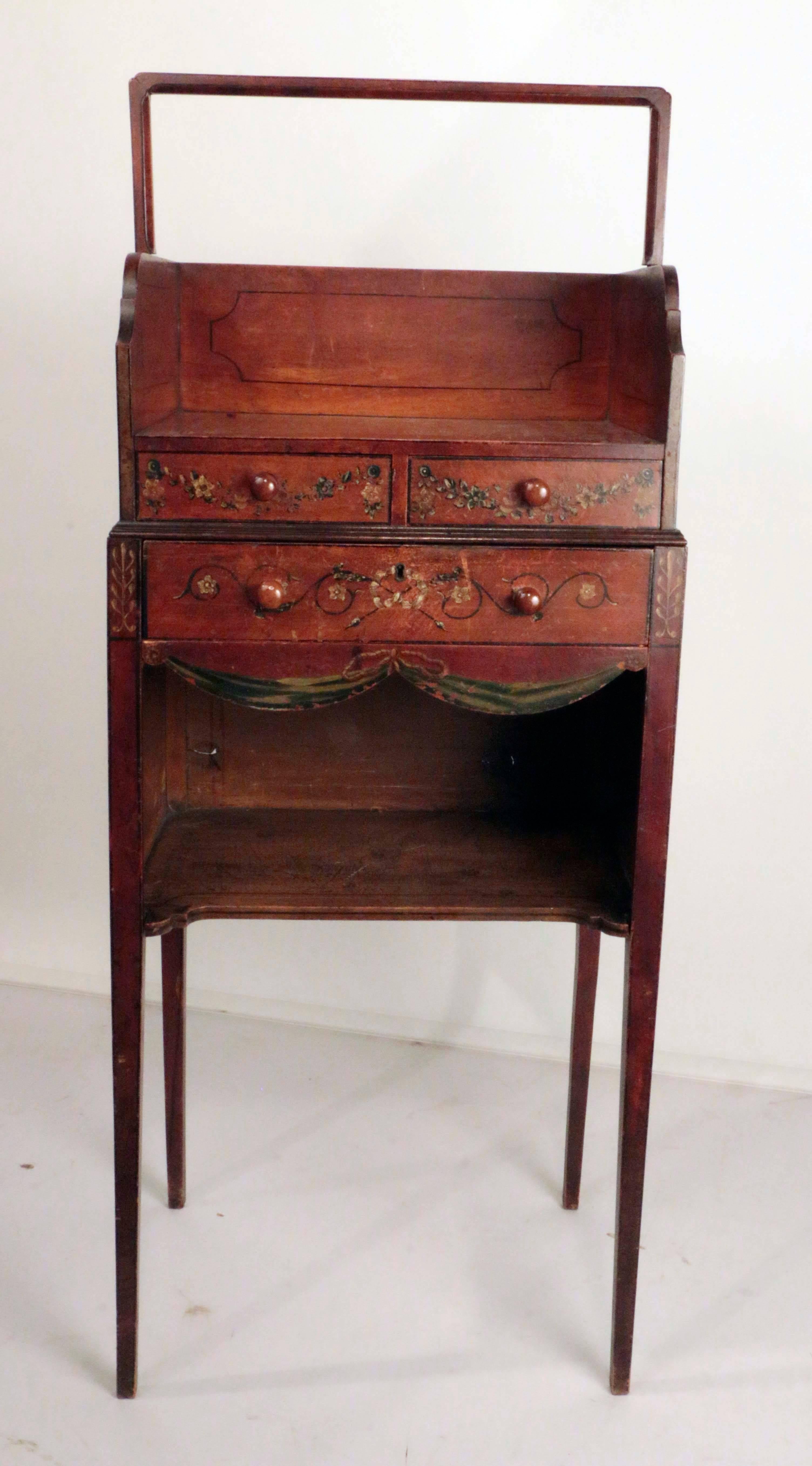 A rare and important Sheraton period painted satinwood cheveret in original finish and with original painted floral swags and garlands. The superstructure with fitted book carrier; the stand with two short drawers above a secretaire drawer, fitted