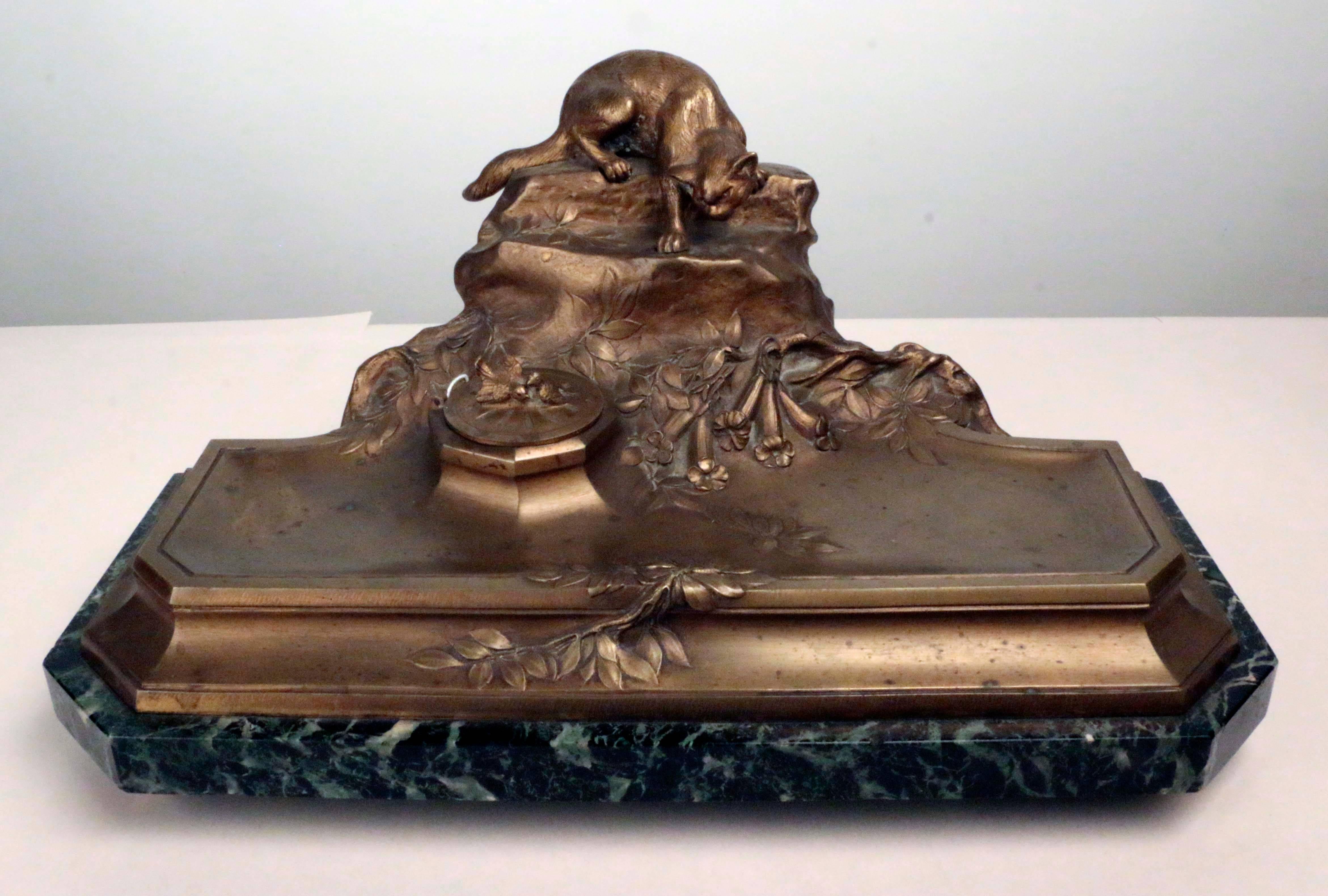 An amusing large bronze inkstand by Dominic Alonzo, modeled as a cat stalking lovebirds, ready to pounce from a rocky outcrop on a floral bank., On a verde antico marble base raised on toupie feet.

Dominique Alonzo was a well- known bronze maker