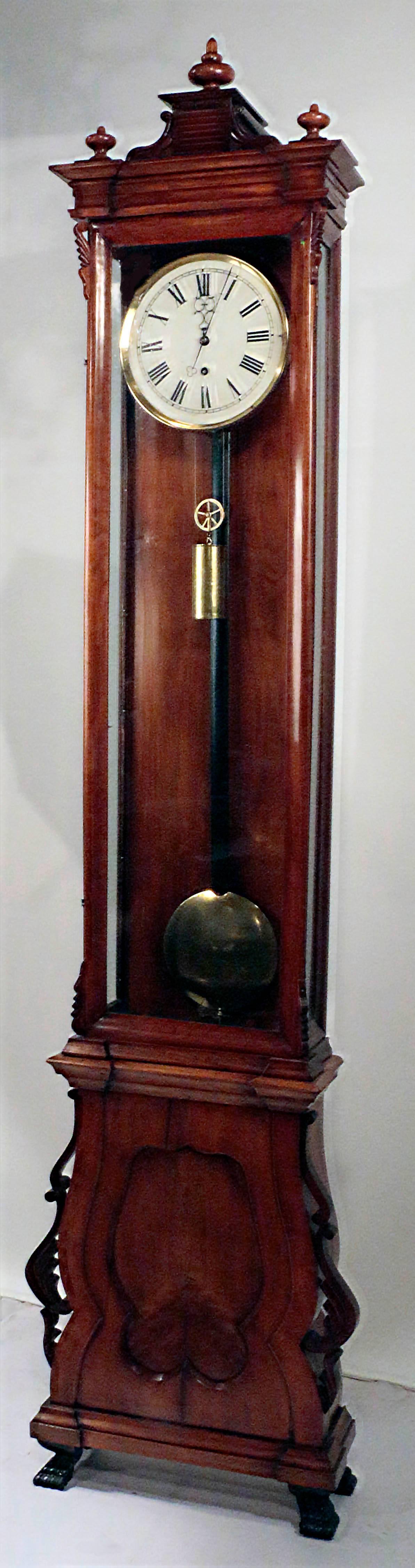 A fine Biedermeier regulator longcase clock in fruitwood case. The upper section with glazed door and sides, the lower, enclosed by single shaped panel. The porcelain dial with Roman numerals within a brass rim and with blue steel hands, with arched