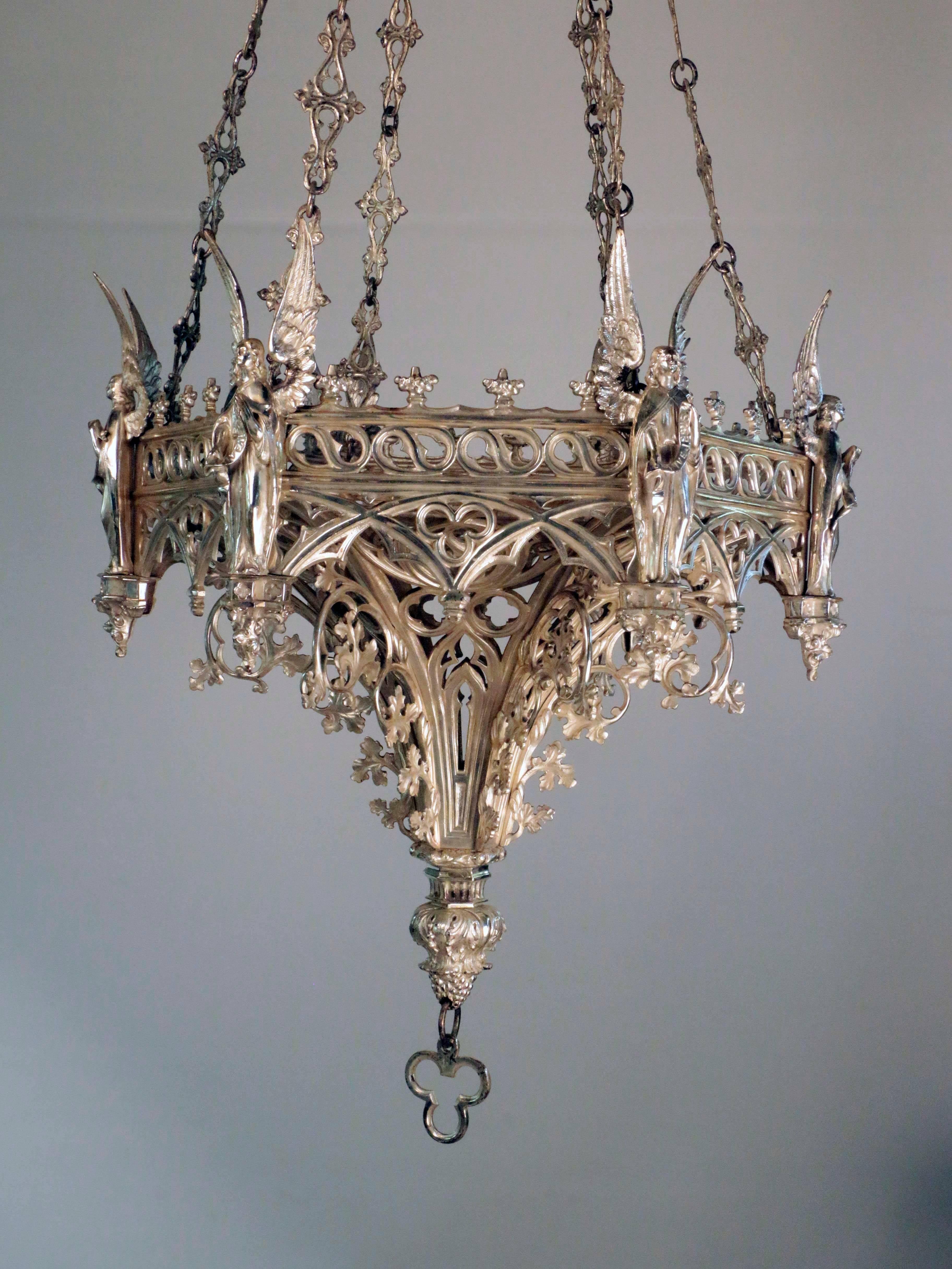 An antique French Neo-Gothic silvered bronze hanging fixture, hexagonal with an angel in relief at each corner amid pierced tracery and crocketing in high Gothic style. The fixture tapers beneath the band of angels and the canopy mimics the