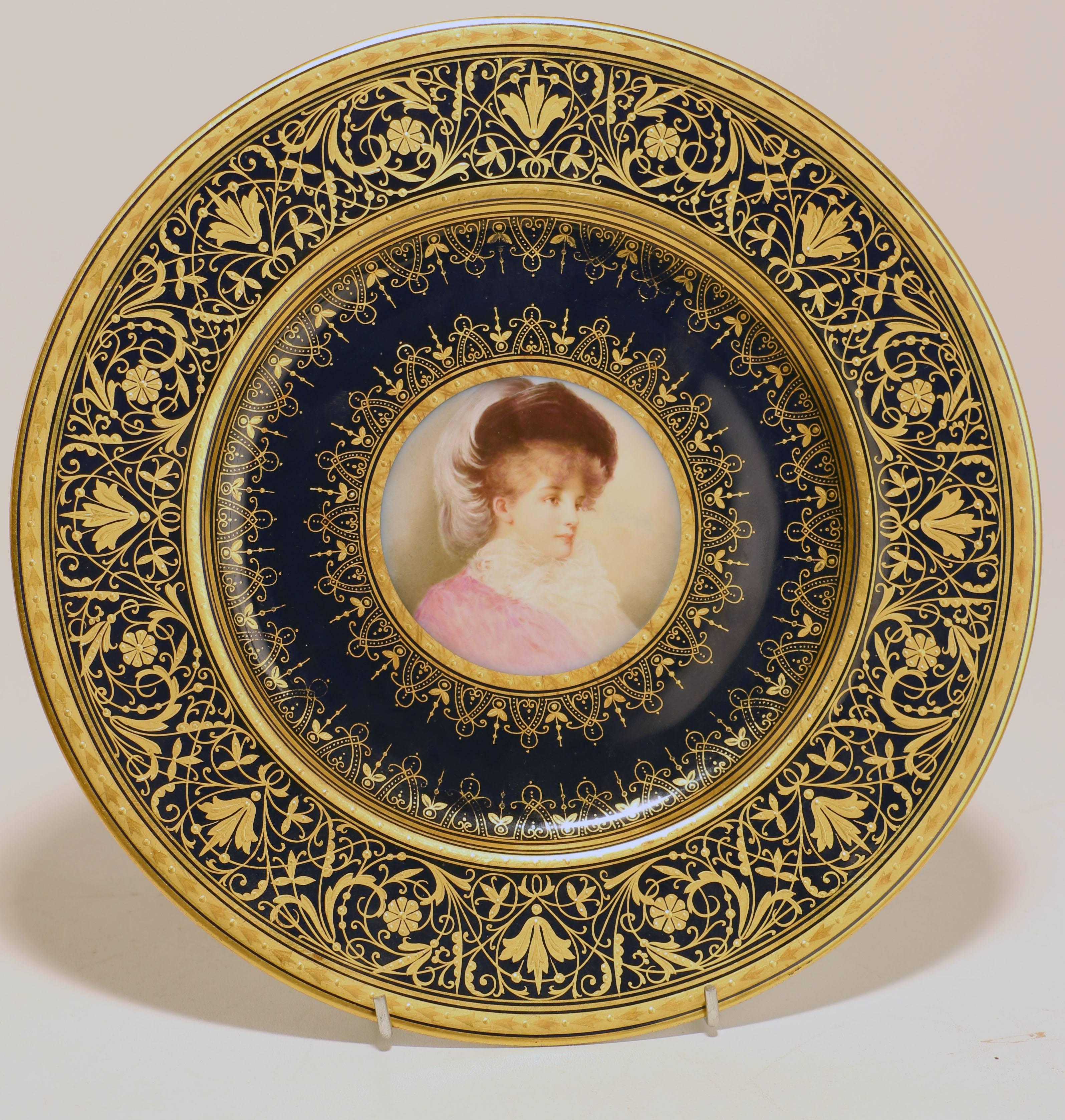 A set of four Old Vienna cabinet plates retailed by  Wahliss.  Each well- painted with a young woman in colorful costume in a circular reserve set on a cobalt blue and gilt ground. Both the painting and the gilding is of the highest quality. Each is