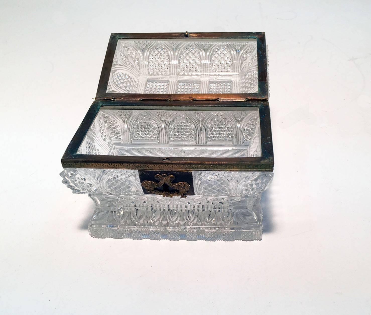 Unlike most similar boxes this one is of sarcophagus form, more costly to produce and more difficult to cut. This sort of quality is very frequently by Baccarat. The high light and clear metal of the glass would also support that view, as would the