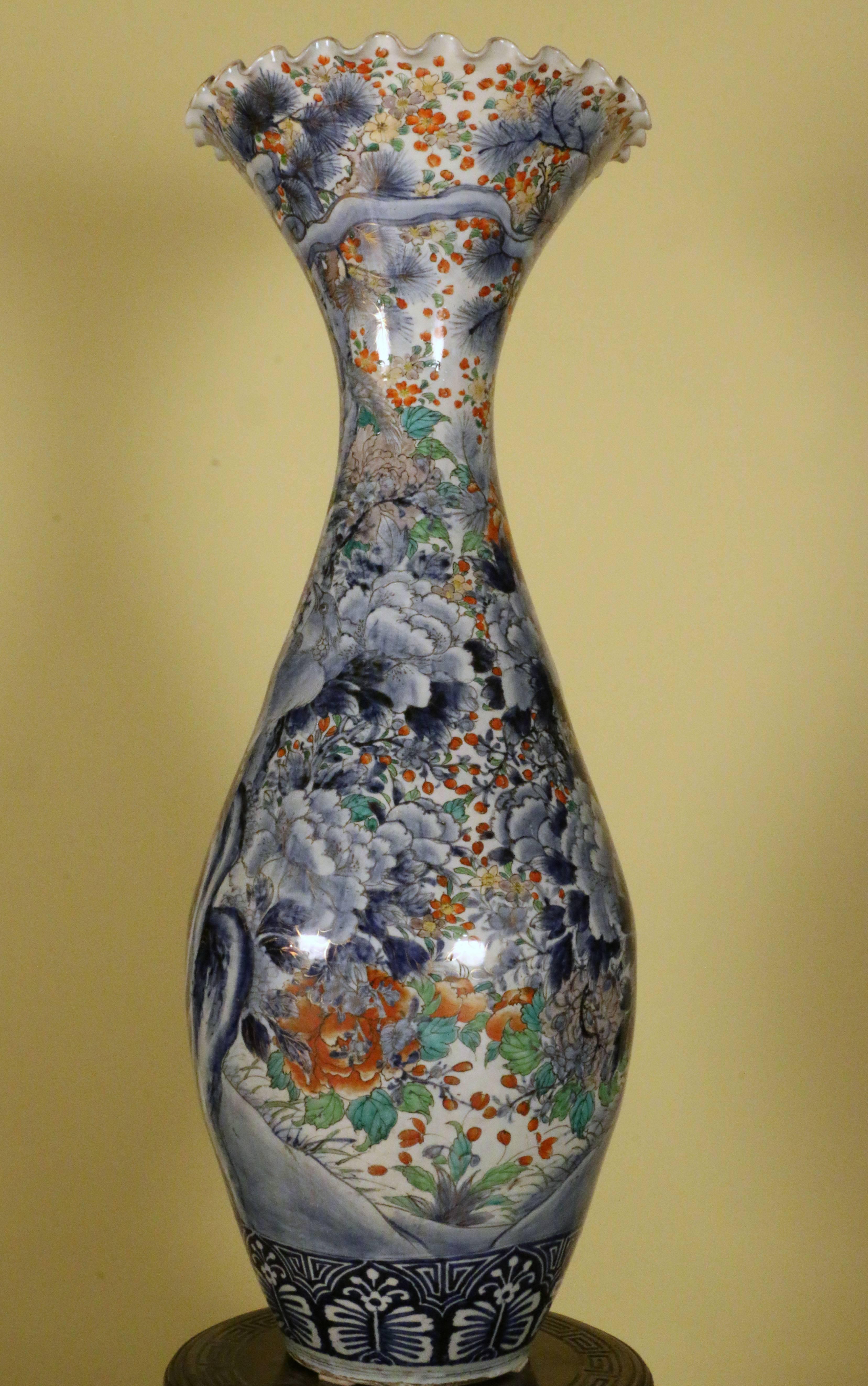This vase has great decorative impact; the ovoid body is painted in polychrome pallet with birds in a flowering landscape, centered on an old tree trunk. The decoration is profuse but well thought out, with two large birds perched on the trunk and