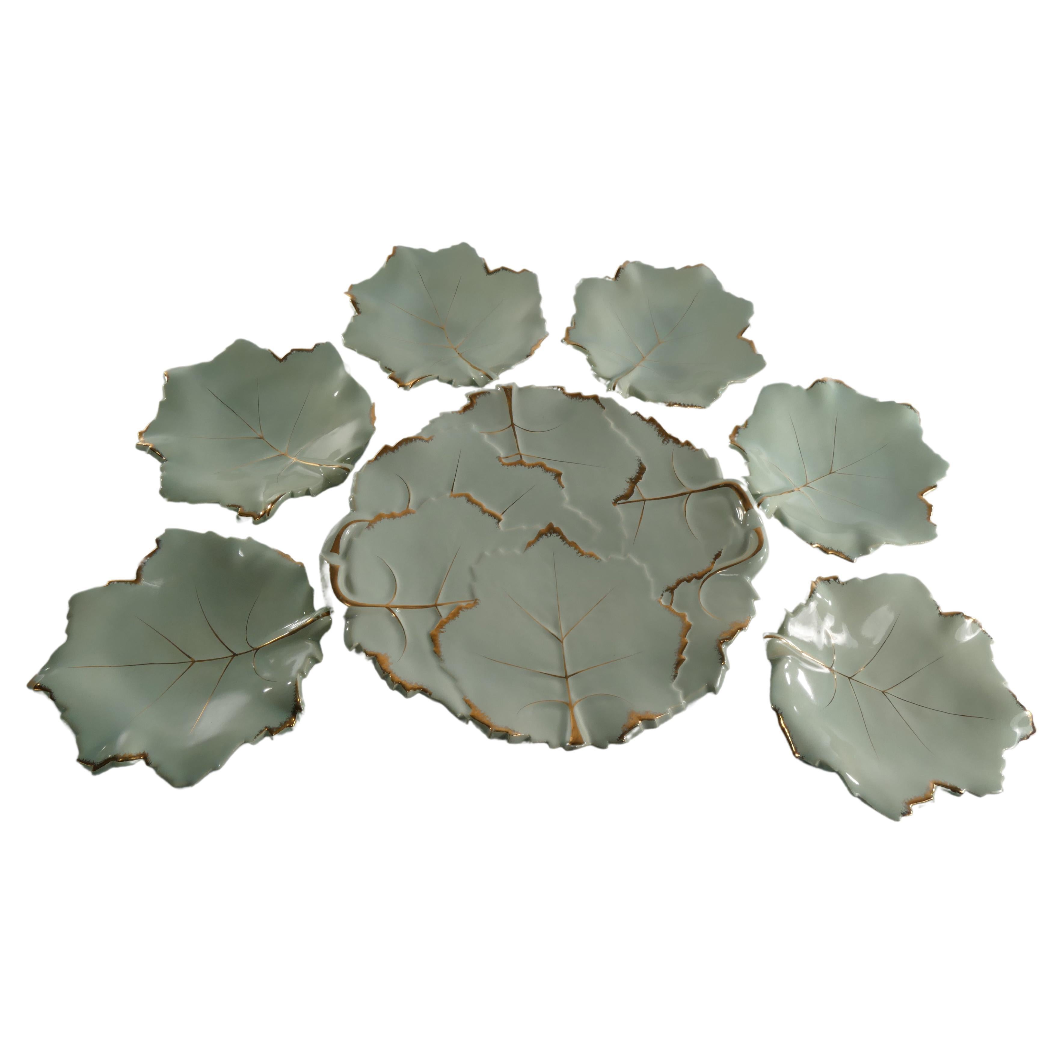 A set of 7 very rare art deco style pistachio color leaf plates with with gold accents from Viloca Paris Caffarelli. The 6 smaller plates constitutes of one leaf each. The larger plate constitutes of many leaves with apparent relief effects