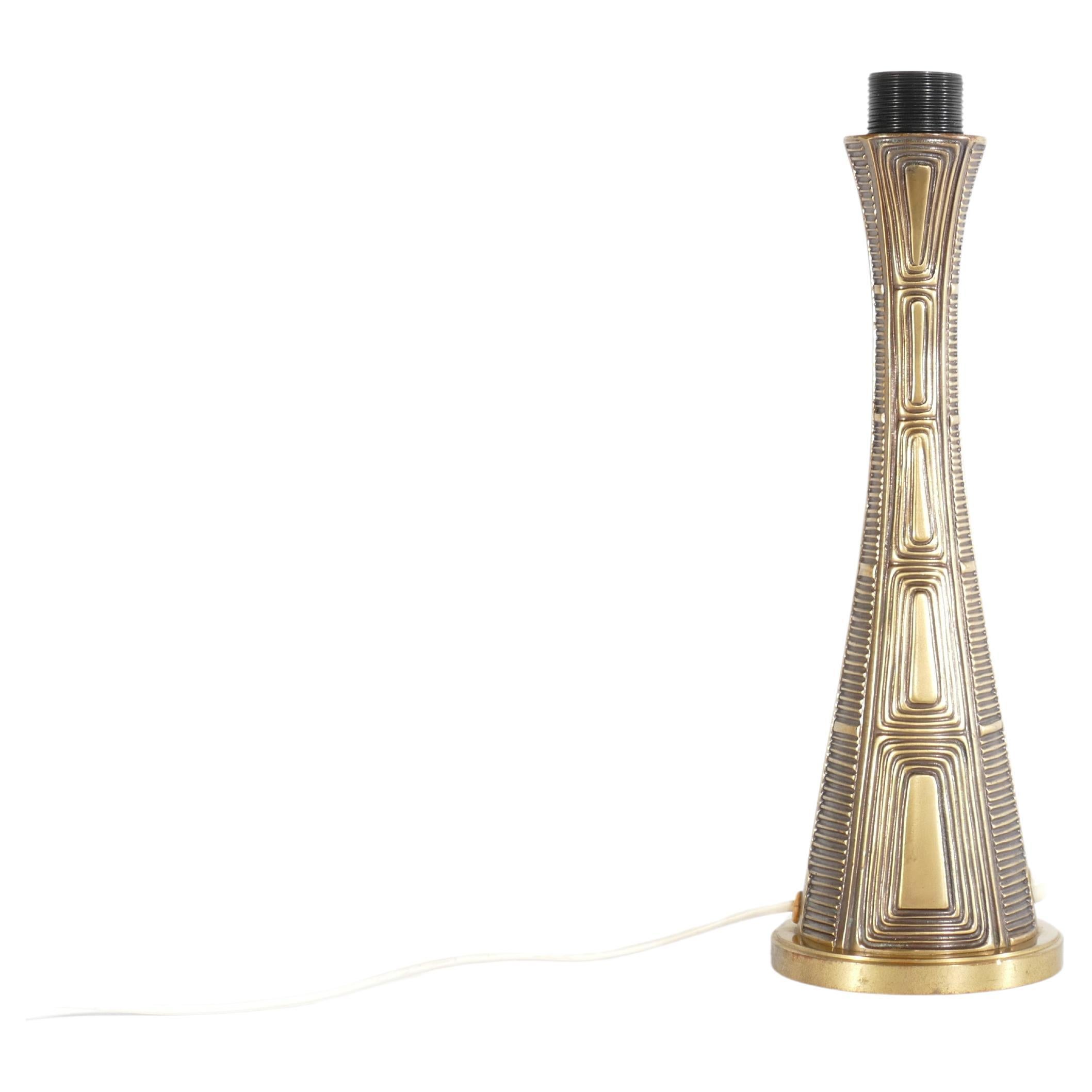 An elegant brass table lamp, a creation of the renowned Swedish sculptor Sonja Katzin (1919-2014), and produced by ASEA in Sweden during the 1950s. This lamp, bearing the stamped model E1140 from ASEA, stands at a graceful height of 37 cm.

Sonja