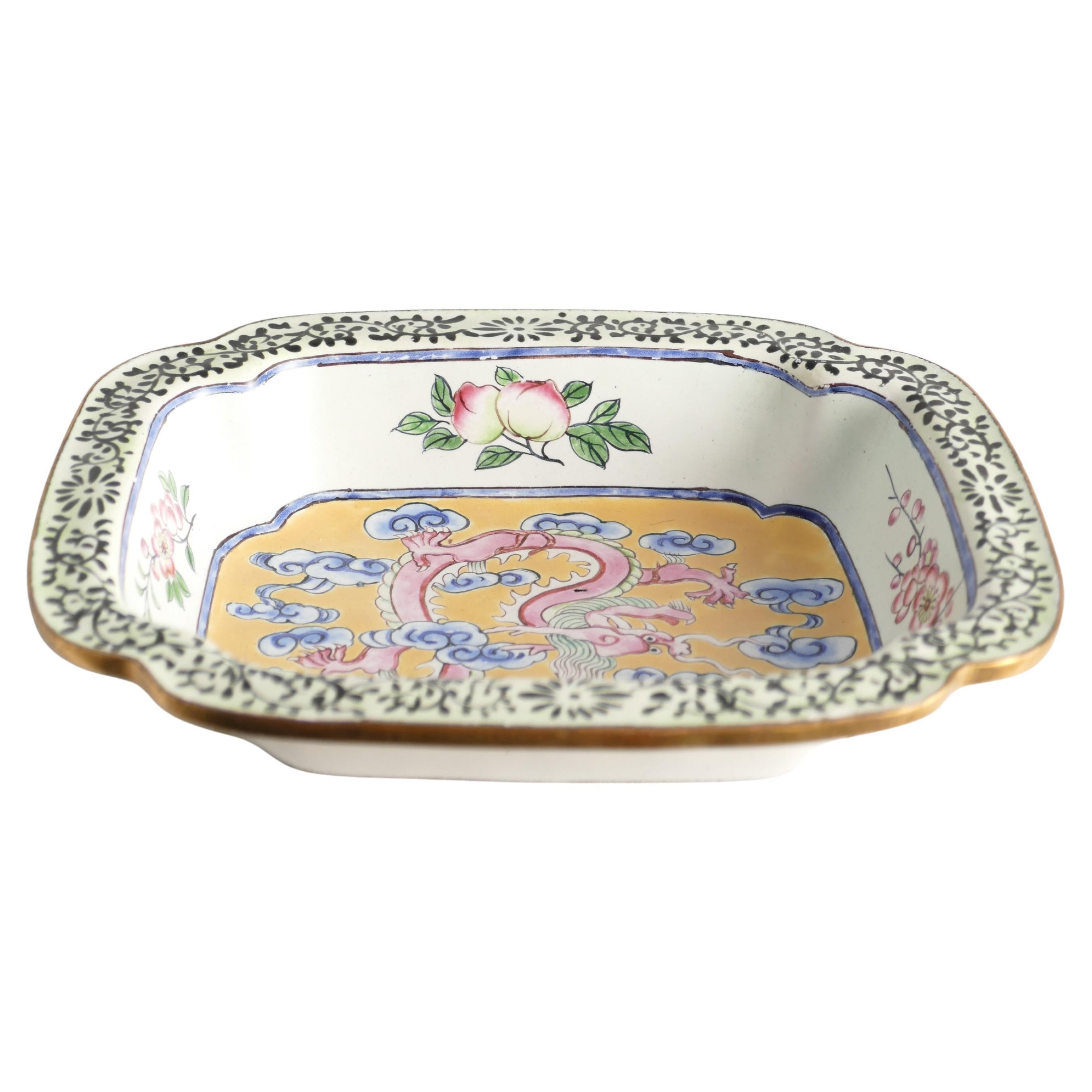 This small and exquisite Chinese Canton Qianlong period enamel square dish features cut corners and is beautifully decorated with a five-clawed pink dragon surrounded by 18 blue ruyi clouds against a vibrant yellow background. The design is accented