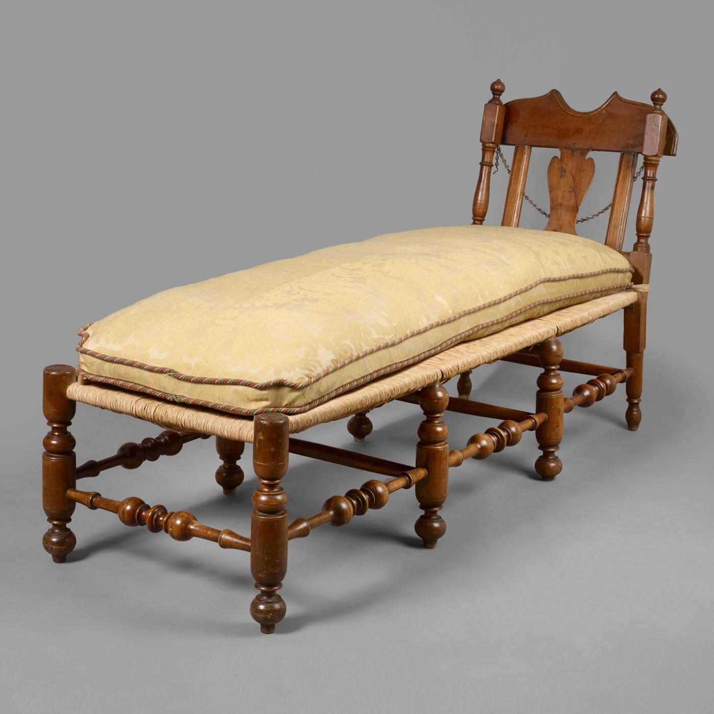 Pennsylvania, circa 1740-1750.
Maple, rush seat.
Condition: Excellent condition, retaining all the original feet. Re-rushed.
This rare example of a Queen Anne daybed is complete having a reclining back with a yoke crest above a vasiform splat.