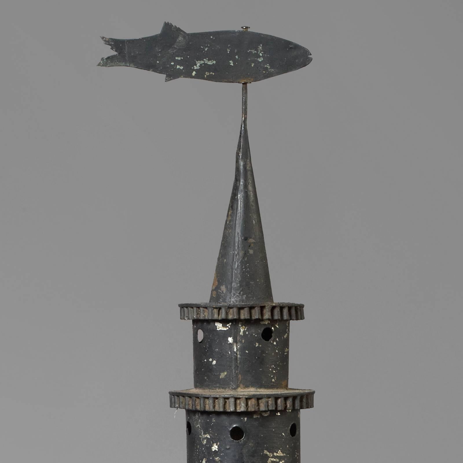 New England, circa 1860-1875.
Iron, tin, glass lamp.
Condition: Fine condition, retaining traces of black paint, minor repairs and imperfections.
Found on cape cod, this rare and possibly unique lantern is adorned with a fish finial. The original