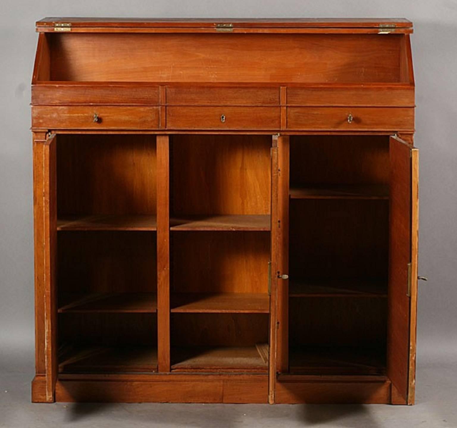 French architect's desk with a slanted, leather inset top. Three drawers beneath and three doors with faux, leather covered drawers, 

circa 1940.