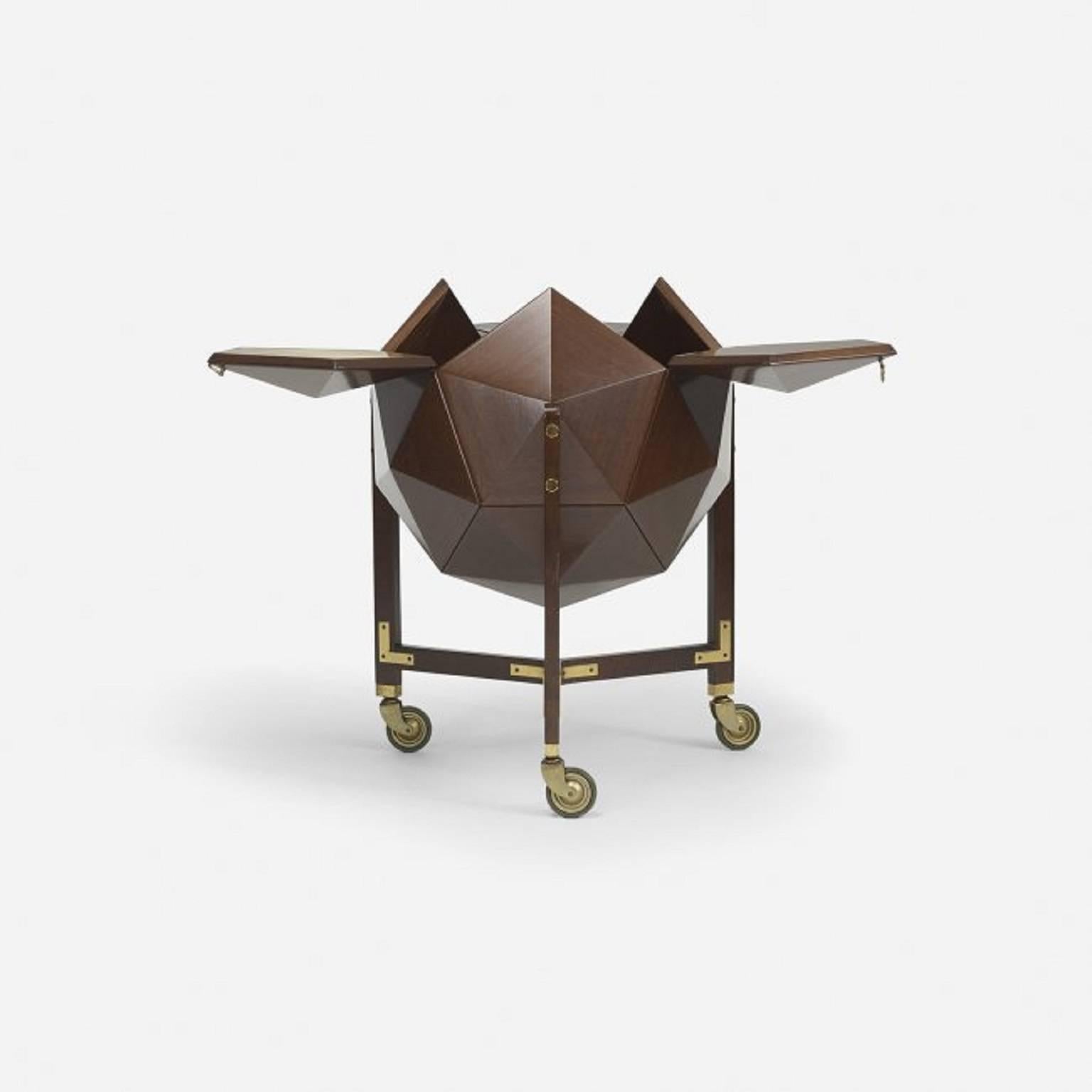 Polyhedron-shaped mahogany bar attributed to Ico & Luisa Parisi.

Three doors with leather covering on the inside open to revel a storage for bottles and barware.
 
Brass, brass-plated steel, leather and rubber fittings.
