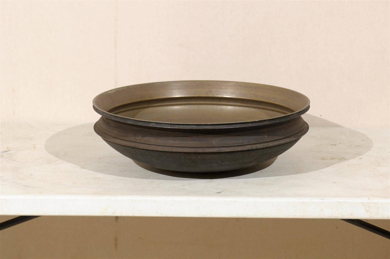A bronze Uruli round shaped cooking bowl from South India. An Uruli is a traditional cookware extensively used is South India. Urulis were used in homes for cooking and in ayurvedha to take medicines. Nowadays, Urulis are used as a decorative bowl