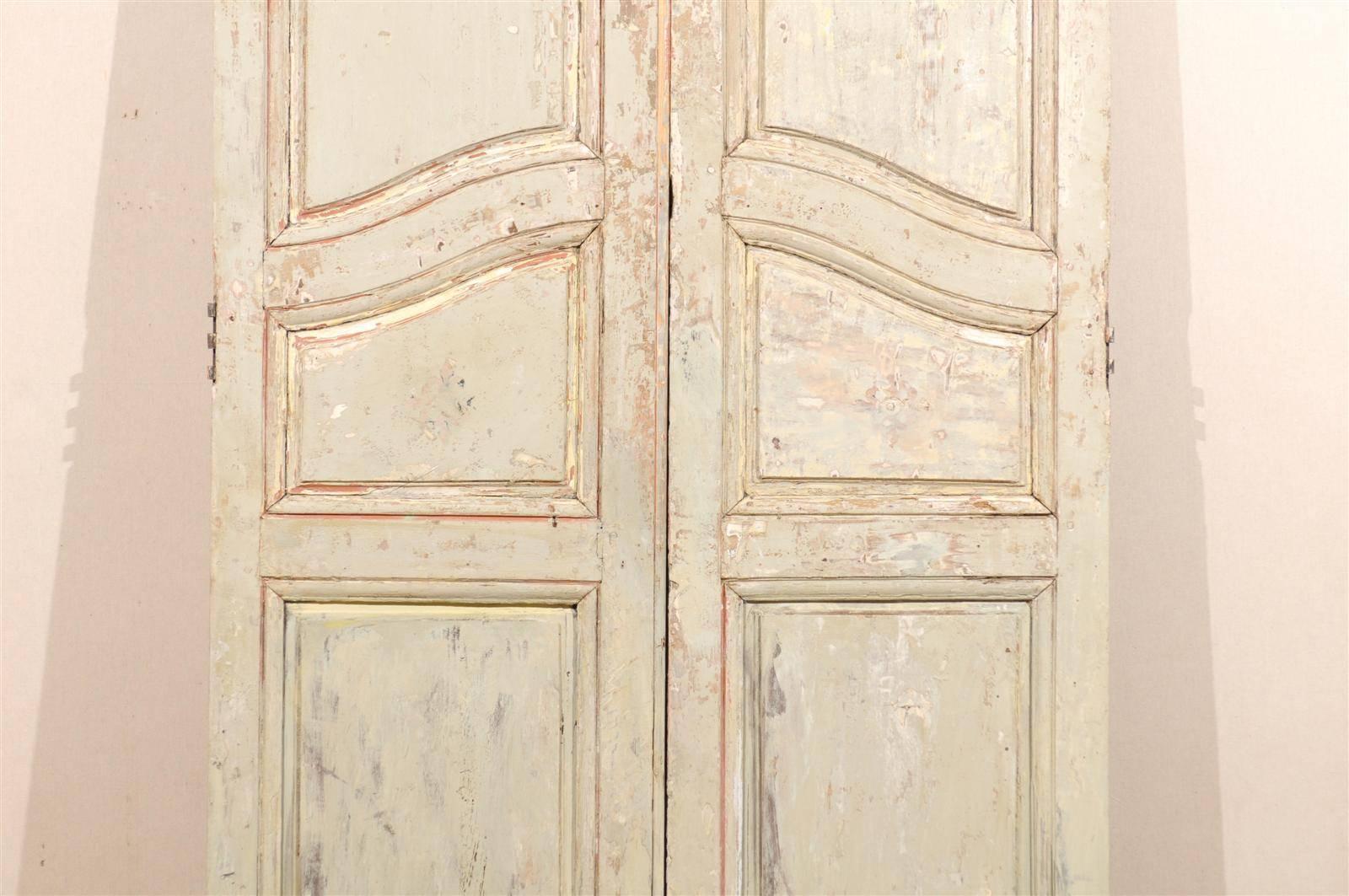 Ein Paar hohe Fenstertüren aus dem frühen 19. Jahrhundert mit geschwungenen, erhabenen Füllungen in der Mitte und originaler Lackierung. Diese Türen eignen sich perfekt für die Abtrennung von ROOMS auf Schienen. Die entsprechende Hardware müsste