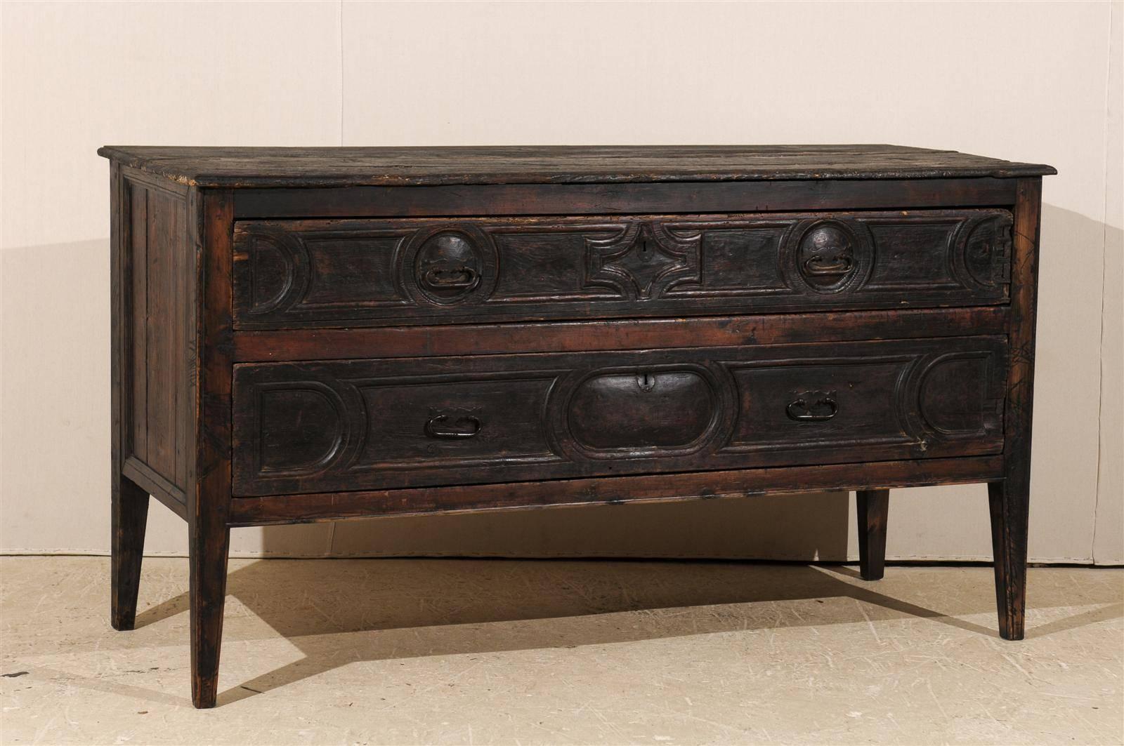 A grand 18th century Spanish two-drawer console table/server. This dark wood Spanish console features two dovetailed drawers decorated with geometrical motifs including medallion and semi-circular motifs. The console is raised on tapered legs.
   