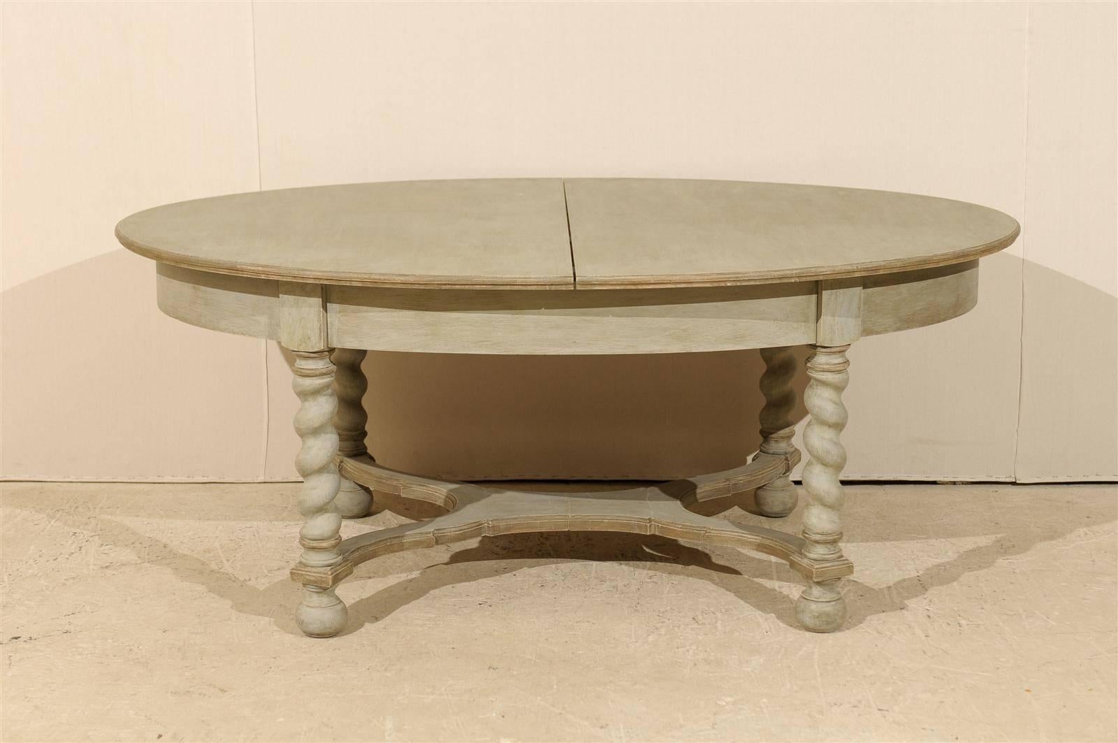 A Swedish Baroque style mid-20th century oval table. This painted wood table features barley twist legs and a nicely shaped cross stretcher. The table is raised on ball feet. The simplicity of the top is nicely balanced by the carving of the legs