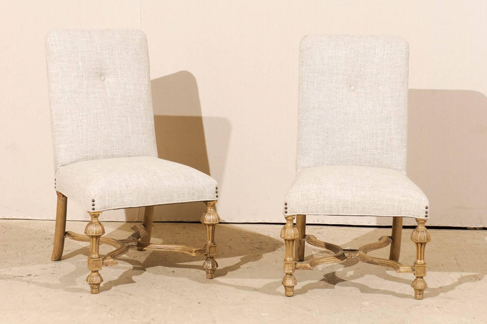 A pair of Italian late 19th century side chairs. These Italian chairs feature nicely carved legs and X-shaped cross stretcher. They are adorned with three nailheads at each corner of the seat. They are painted light grey over gold color. The pair