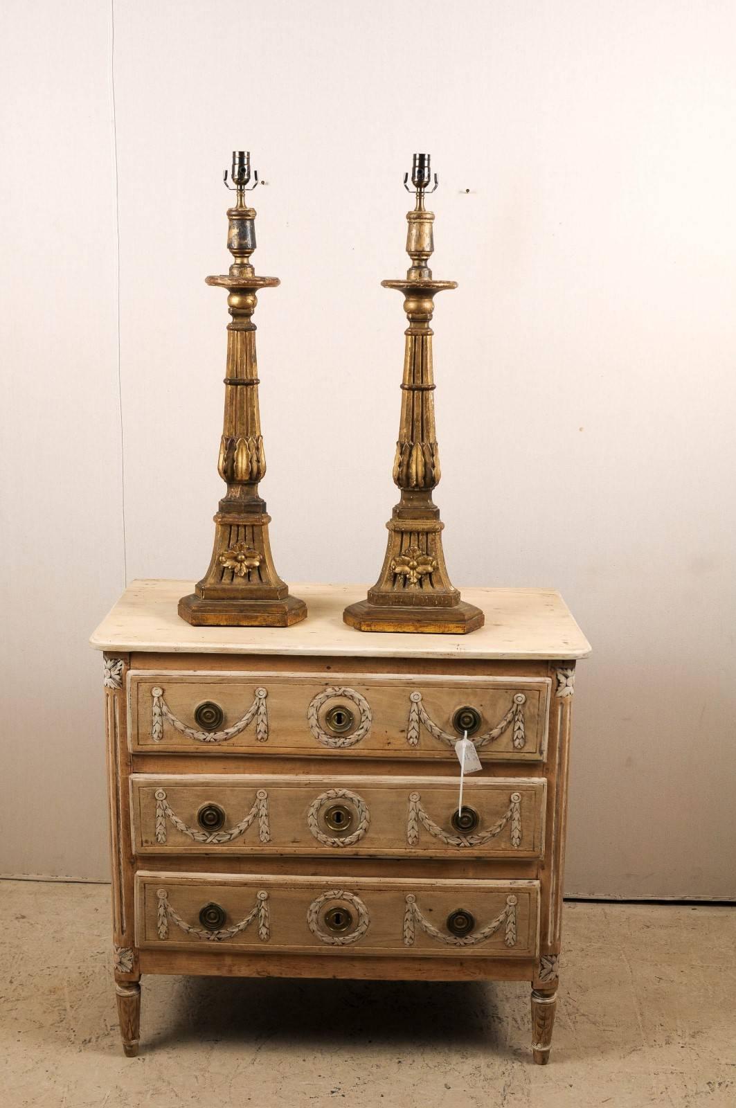 Une paire de chandeliers transformés en lampes de table. Cette paire de lampes de table italiennes en bois du XIXe siècle présente un chandelier triangulaire cannelé décoré de motifs floraux et d'une sculpture de fleurs. Des motifs de feuilles