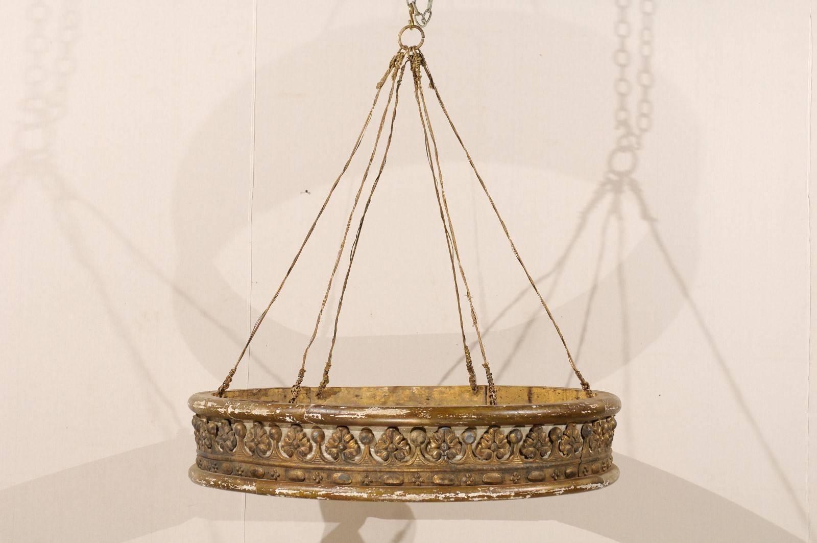 Une couronne de lit italienne du milieu du XIXe siècle, peinte et en bois doré. Cette corona de lit italienne présente un motif joliment sculpté s'enroulant autour de sa face avant, rappelant une couronne royale, sur un fond peint gris beige. Sa