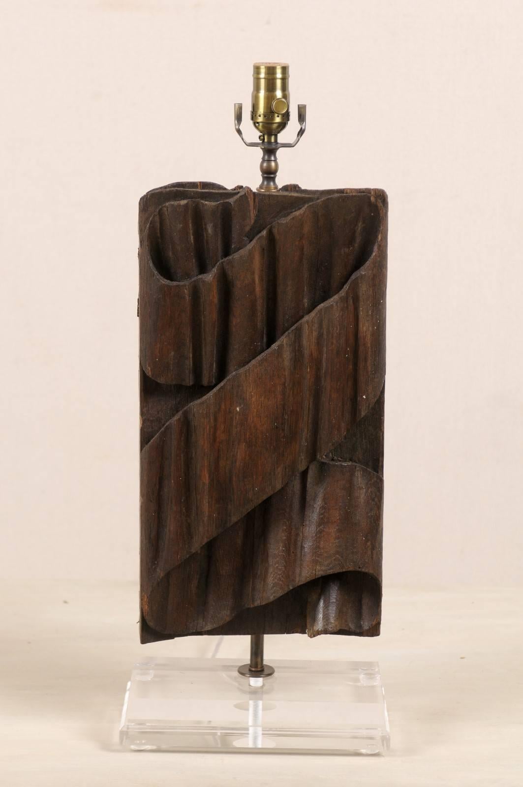A single Italian fragment from the 19th century fashioned into a table lamp on new custom Lucite base. This Italian fragment has a pleated ribbon like motif carved along its body. This table lamp is a deep brown color with a rich red hue emerging