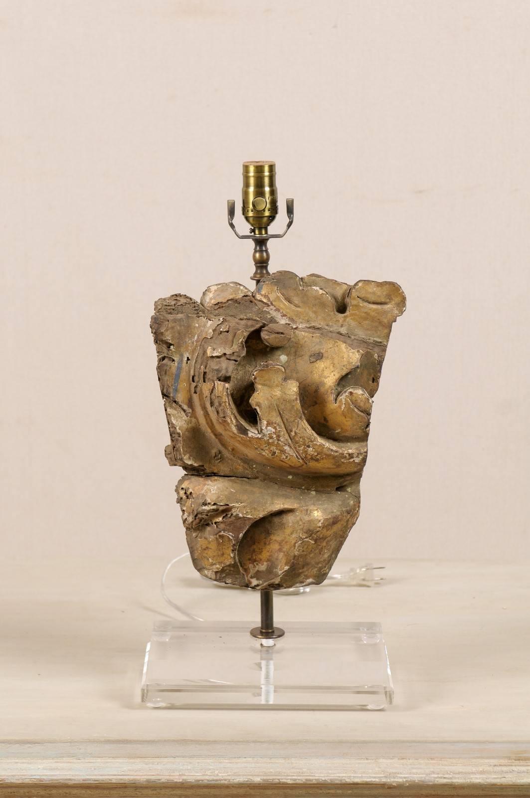 An Italian gilded wood fragment fashioned into a single table lamp on a custom Lucite base. This Italian fragment is dated early 19th century. This fragment has dynamic colors, including gold, blue and brown. This table lamp has been wired for the