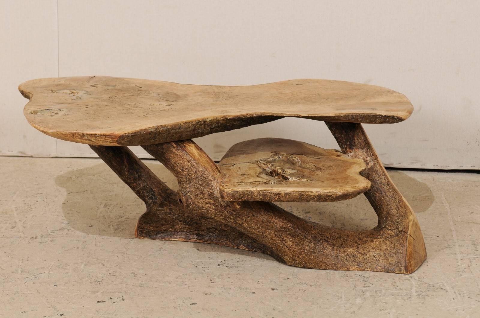 A Spanish two-level cypress wood coffee table. This unique Spanish natural wood table has been made from the slab and branches of the Mediterranean cypress tree. The top has a lovely, almost hour glass shape. There is a second level which juts out