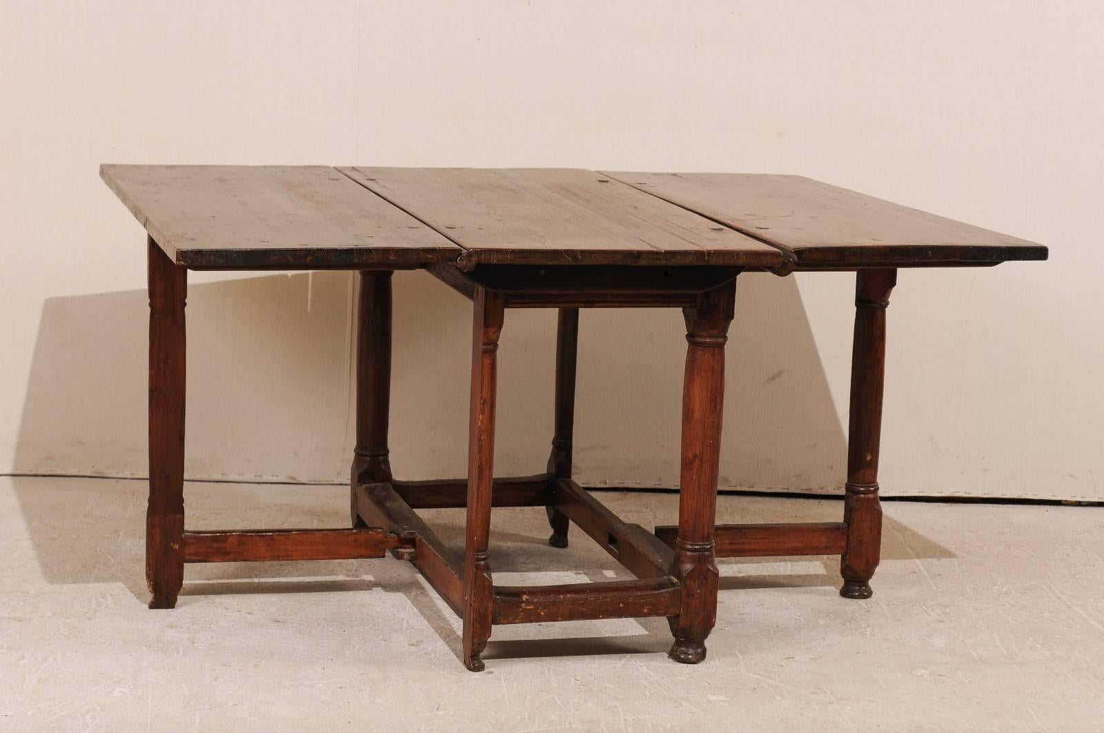 A Swedish 18th century period Baroque gate leg table. This 18th century Swedish table features two drop leaves and gate legs. This table is made from fir wood. This fantastic Swedish table offers great functionality, as it is narrow when the leaves