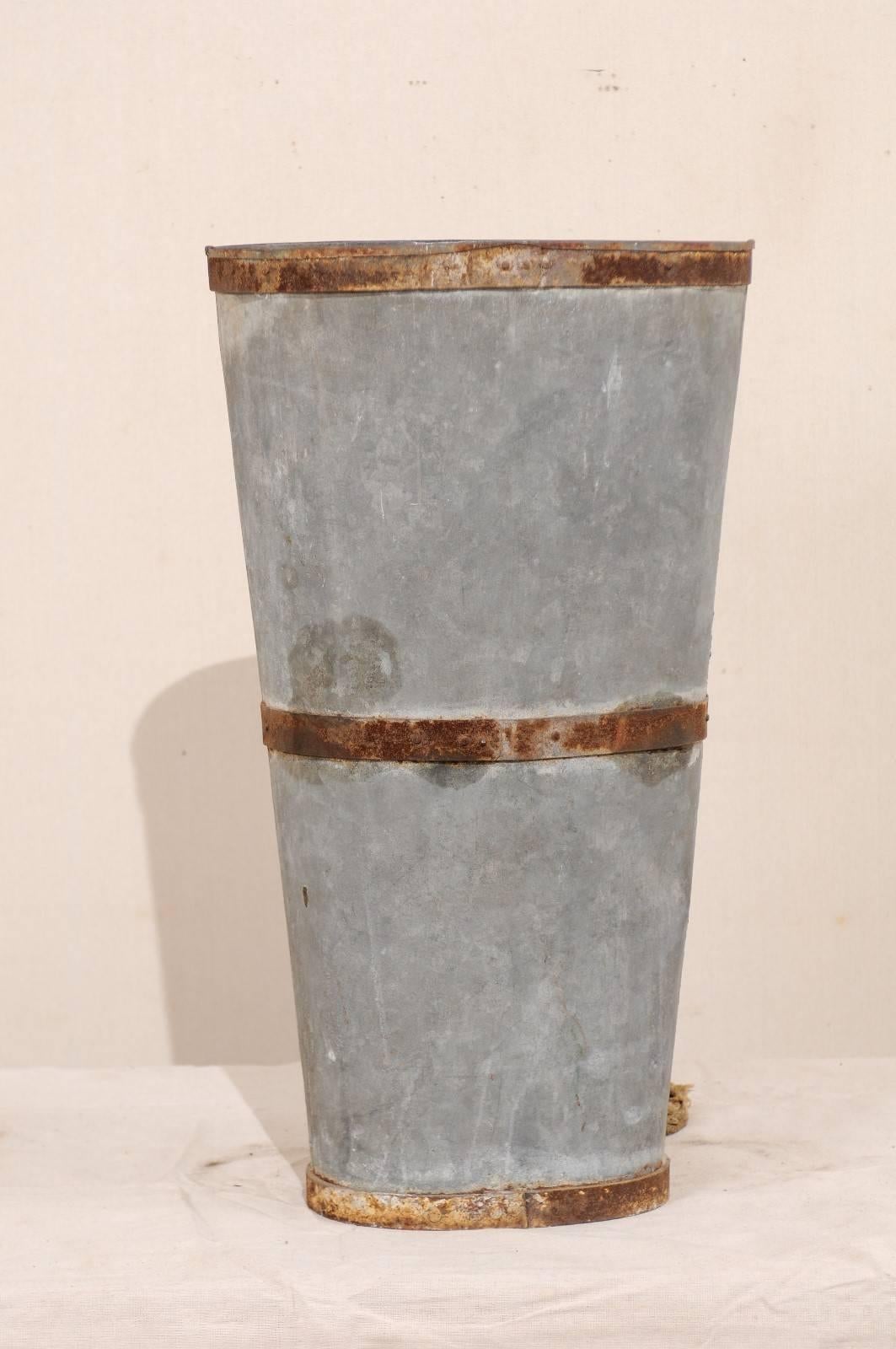 A mid-20th century, French grape harvest back hod. This French grape hod was once used in the countryside of France by pickers harvesting grapes. This hod is constructed of metal, which has a nicely aged patina. There are also some remnants of it's