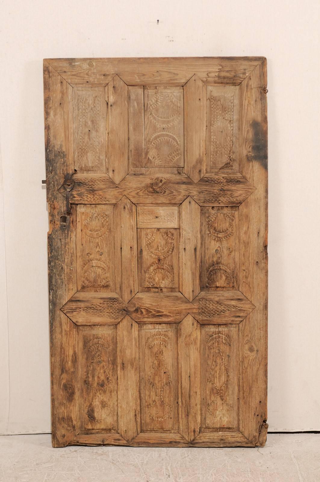 A single European 19th century nine panel wood door. This cute little door features a nine panel front which has been adorn within each recessed panel and two center rails with a series of rustically chiselled designs. The door has a natural wood