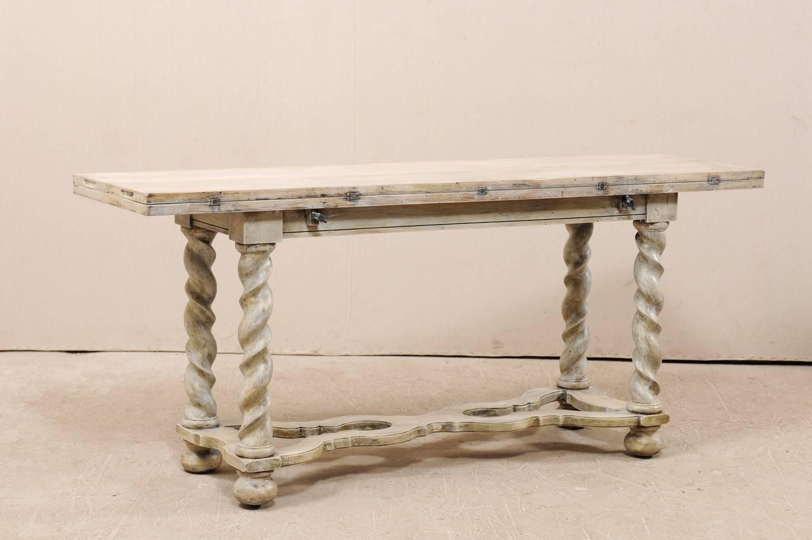 A vintage American convertible painted wood console table. This unique table offers a variety of uses with the folding function, in which the extending leaves fold inward and sit upon the base of the table, giving it more of a console look. This