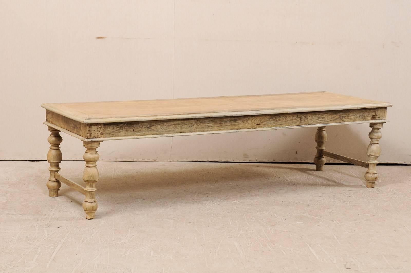 A Belgian mid-20th century wood coffee / centre table. This Belgian coffee table of wood features a long, rectangular top and nicely turned legs. The skirt has nice, clean lines which mimic the top of this table. The legs are connected by a