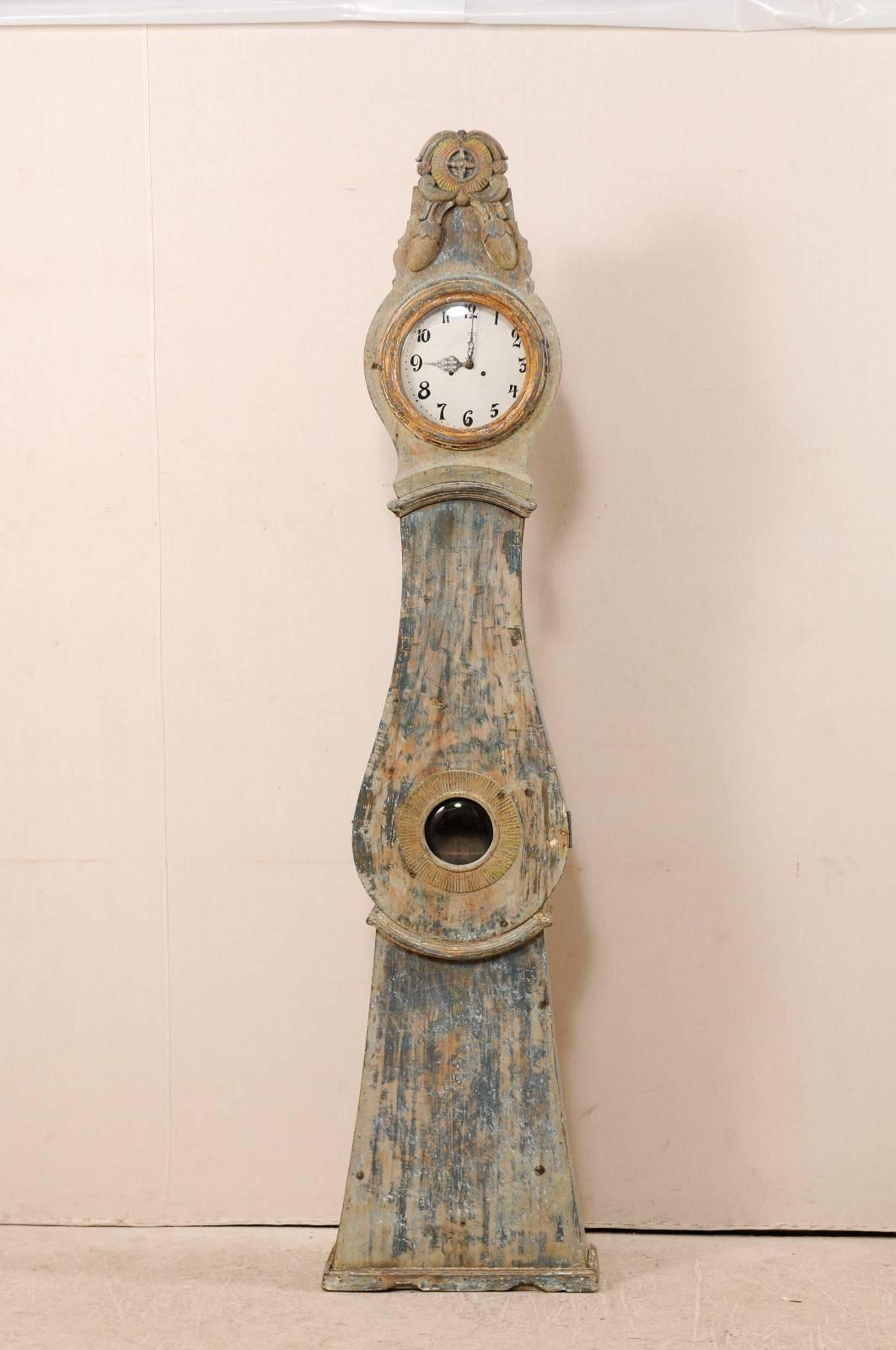 Eine bemalte Holzuhr aus dem 19. Jahrhundert aus Nordschweden. Diese schwedische Uhr aus der Grafschaft Norrbotten, Schweden (nördliche Region), weist ein schön geschnitztes, übertriebenes und erhabenes Wappen auf, das von einem Paar hängender