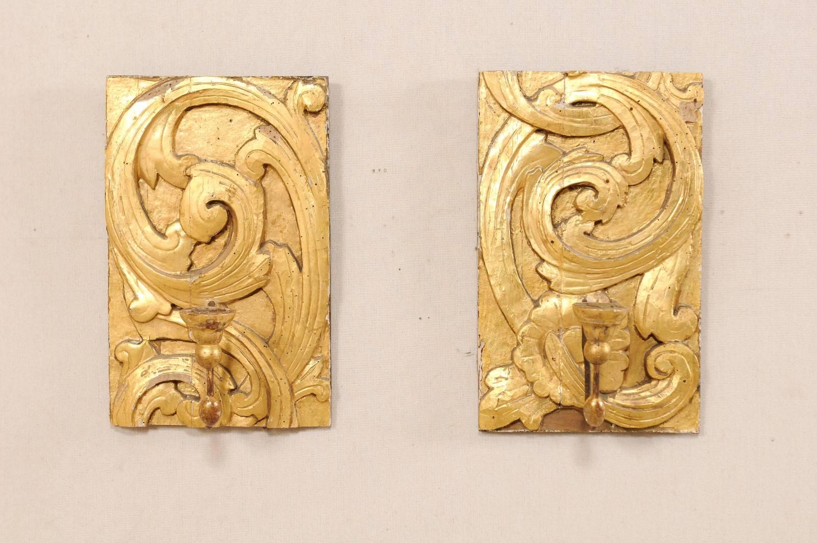 A pair of Italian 19th century gilded fragment sconces. This pair of Italian candle sconces, from the 19th century, feature gilt and gesso over carved wood. The carved wood back plates feature a scrolled acanthus leave motif. Each sconce has a