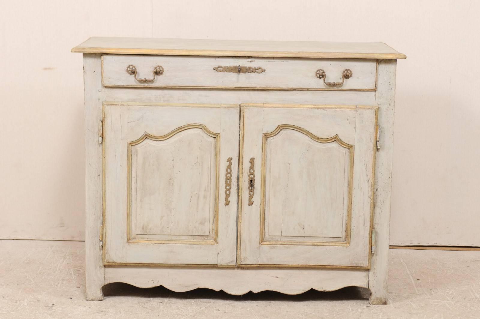 A French 18th century painted wood buffet. This French antique painted wood buffet features a single drawer over two doors. The panels on the doors have been delicately carved. There are two oblong rectangle recessed panels at each chest side. The