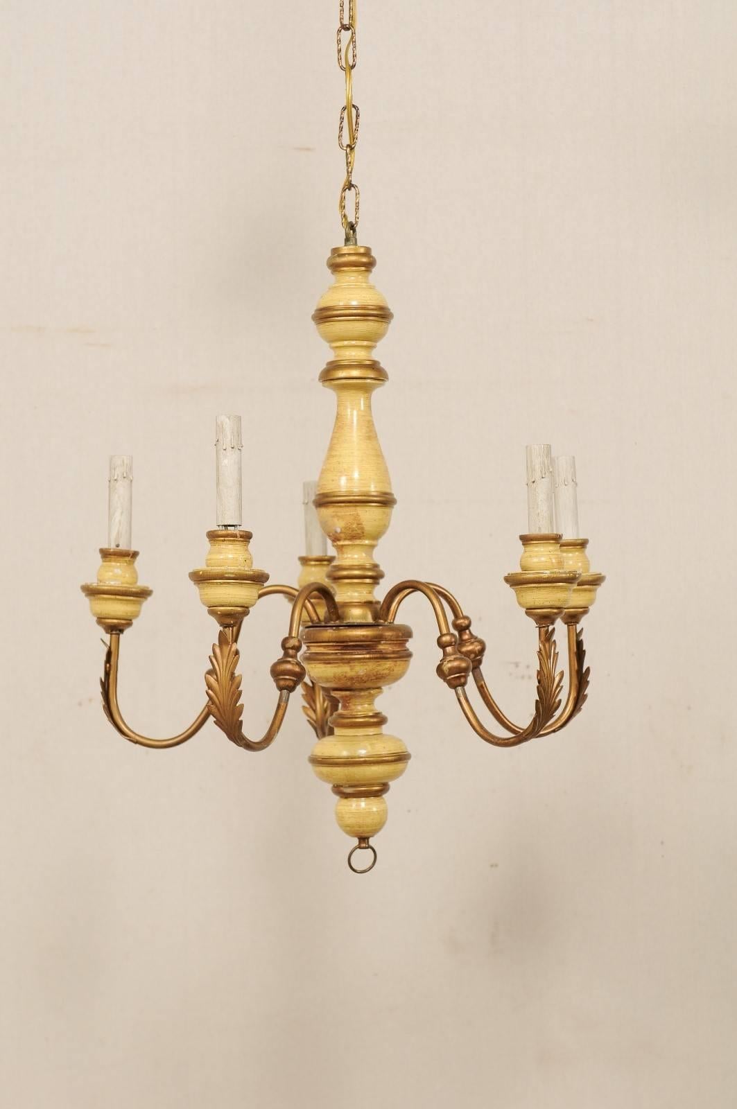 A French five-light painted wood and metal chandelier. This mid-20th century French chandelier features a carved wood column with fluid s-shaped swooping arms lifting up and out from its centre. This column features a serious of bulbous shapes, with