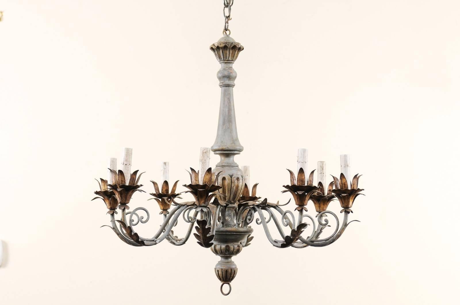 A French painted and gilded eight-light wooden chandelier from the mid-20th century. This French chandelier has carved central column with bottom ring finial, lovely scrolled metal arms that are decorated with acanthus leaf motifs. At the end of