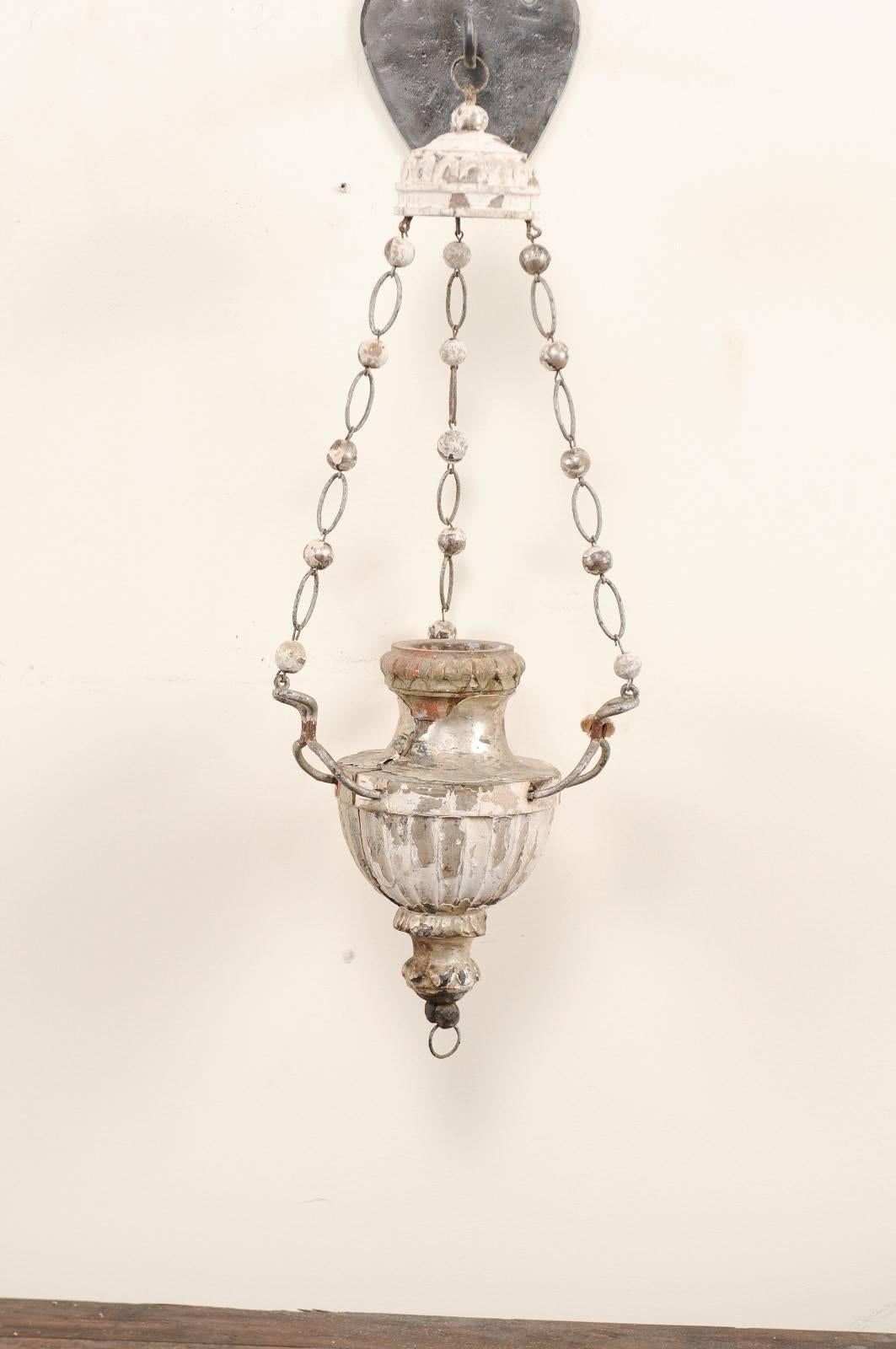 A pair of Italian, 19th century hanging sconces. This pair of antique Italian sconces have been fashioned from hanging church lanterns of silver gilt and gesso over carved wood. Three uniquely designed chains, with decorative carved wood ball