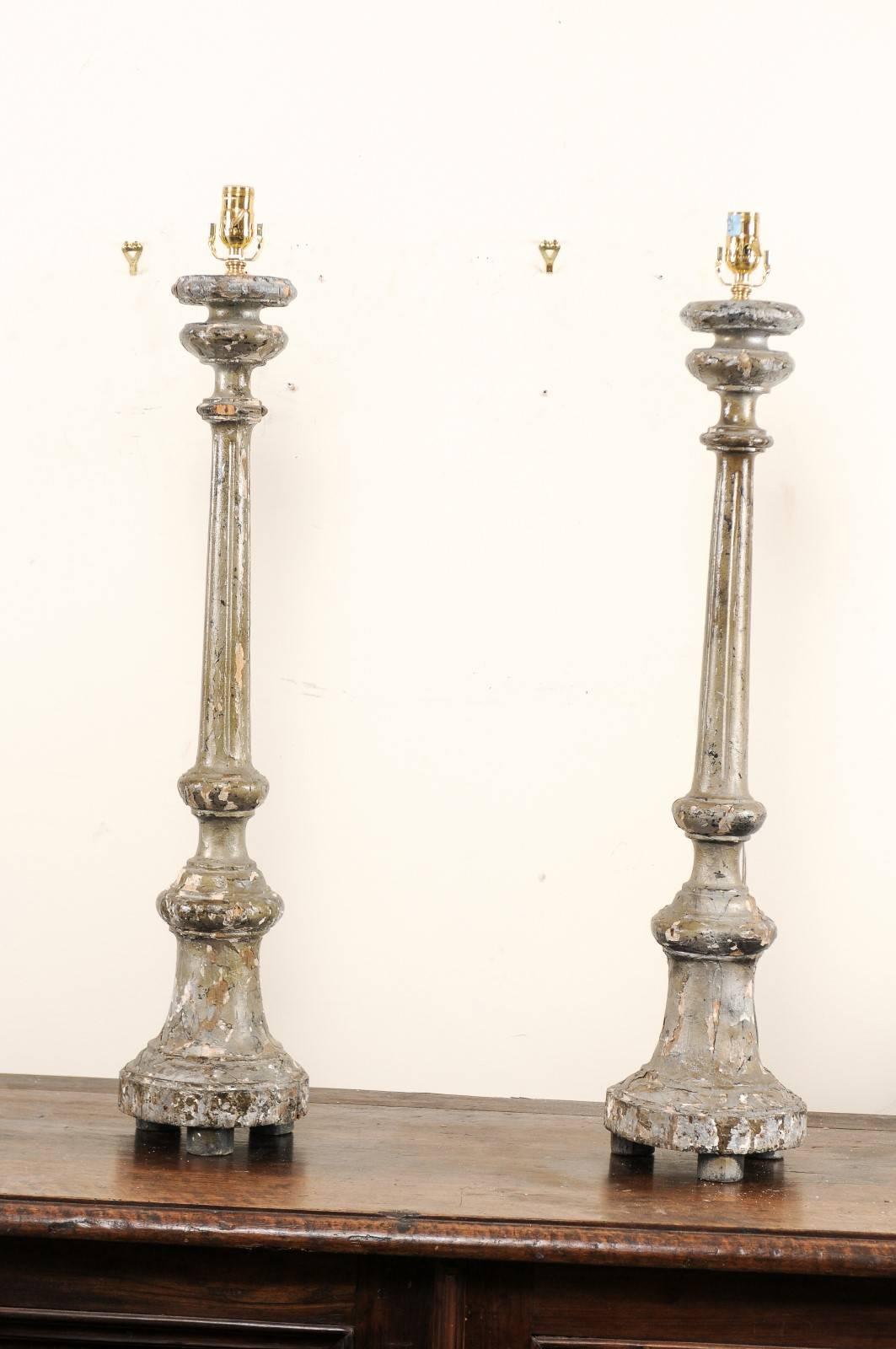 A pair of Italian 19th century carved wood altar sticks made into table lamps. This pair of Italian table lamps have been fashioned from antique altar sticks with silver leaf and gesso over carved wood. They are nicely shaped with fluted details and