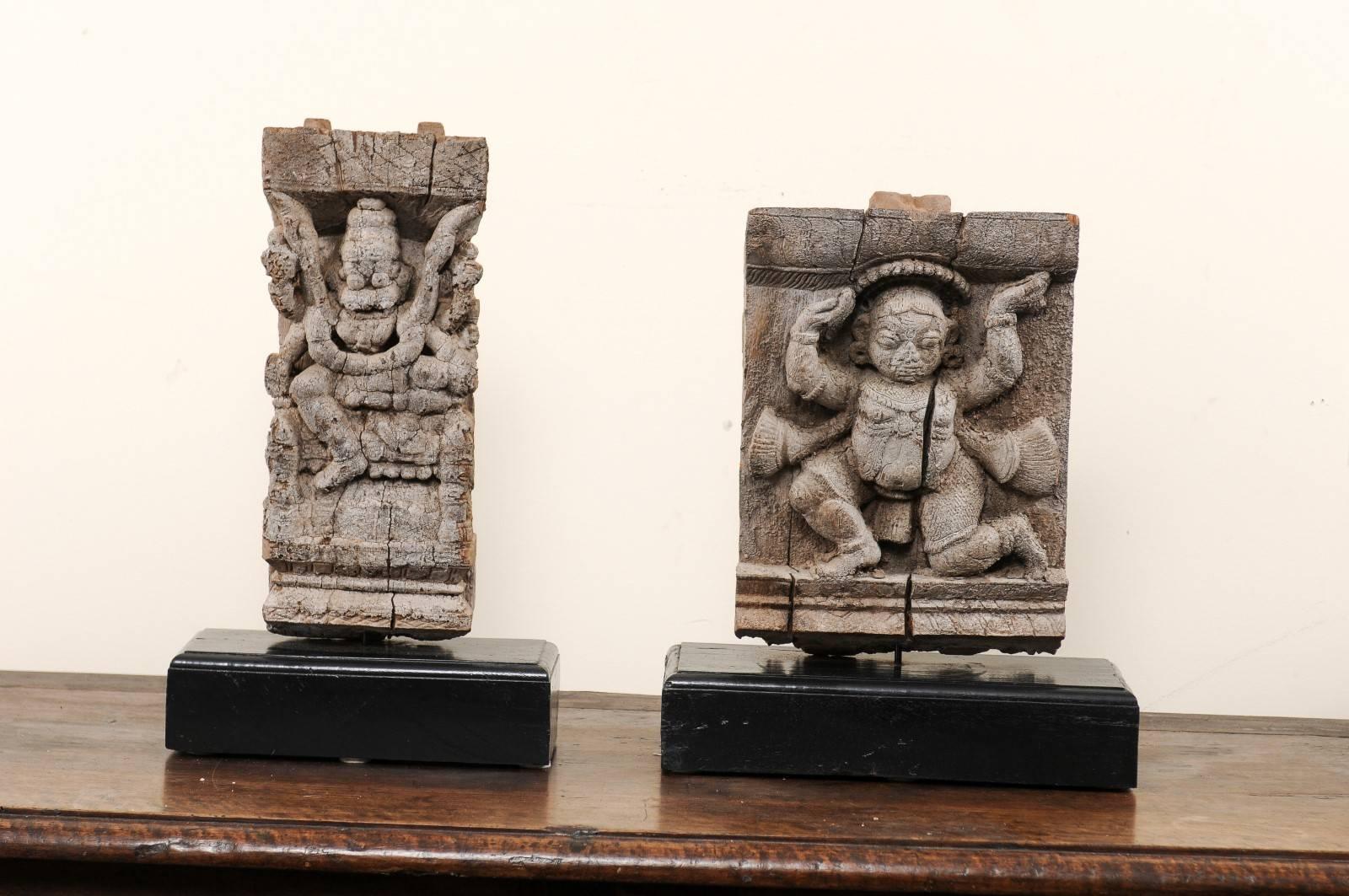 A pair of 19th century Hindu temple fragments. This pair of antique fragments were elements of a section of hand-carved wood frieze, within a temple in India. They have each been mounted on a custom-made, rectangular-shaped, and black painted wood