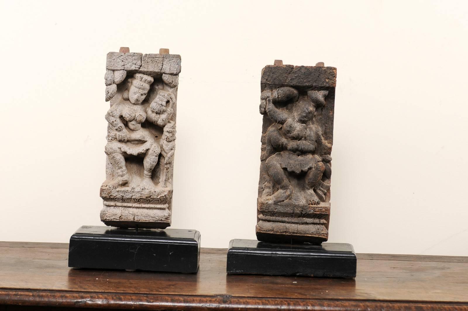A pair of 19th century Hindu temple fragments. This pair of antique fragments were elements of a section of hand-carved wood frieze, within a temple in India. They have each been mounted on a custom-made, rectangular-shaped, black painted wood