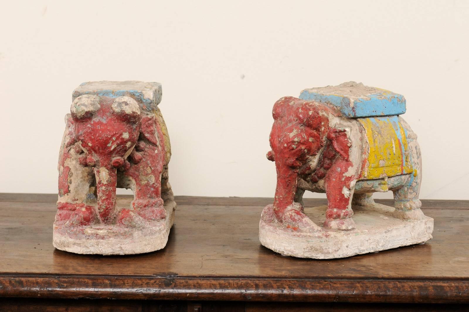 A pair of 19th century painted stone elephants. This pair of antique stone elephants are made from capital bases from a Temple in the Southern regions of India. They have been hand-carved and each retain remnants of their original paint. This pair