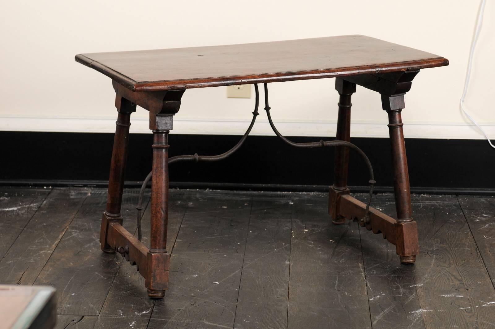 An early 19th century Italian coffee table. This antique Italian coffee table of walnut wood, features a rectangular-shaped top supported by a pair of trestle styled legs at either side, and supported by a beautifully curved center stretcher, whose