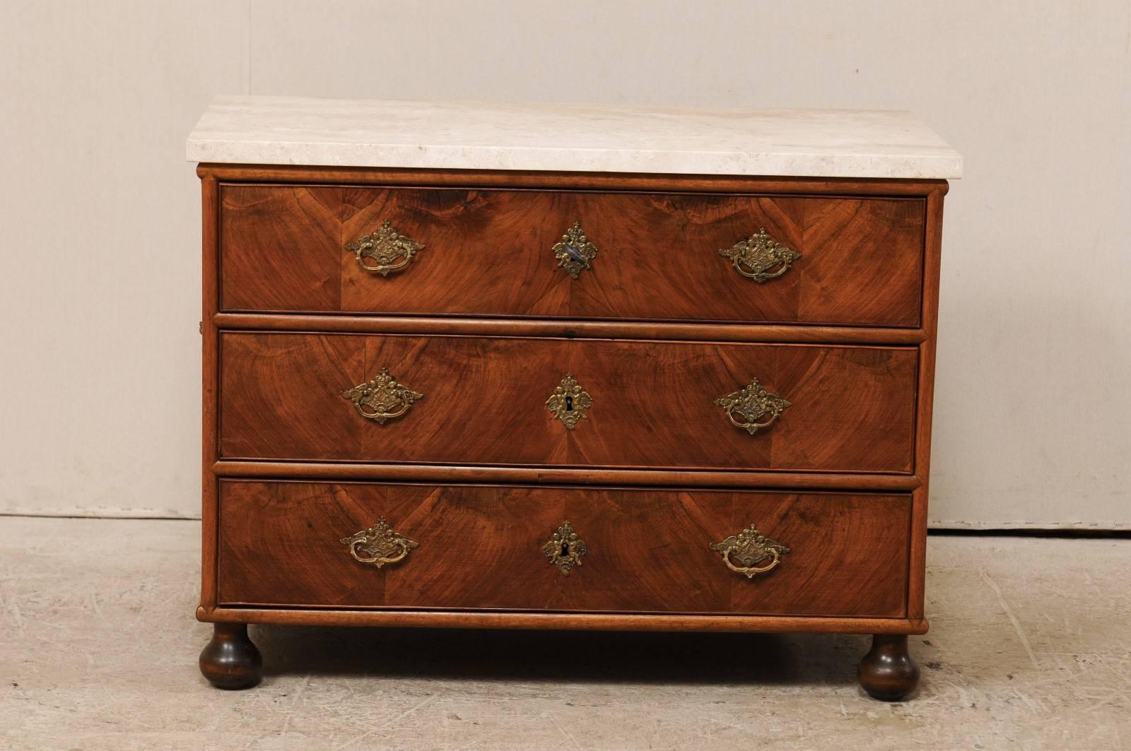 An 18th century, Swedish marble top wood chest. This antique Swedish chest feature exquisite wood grain throughout, three drawers which are adorn Rococo hardware and is presented upon four fabulously balled feet. There are nice rectangular pulls