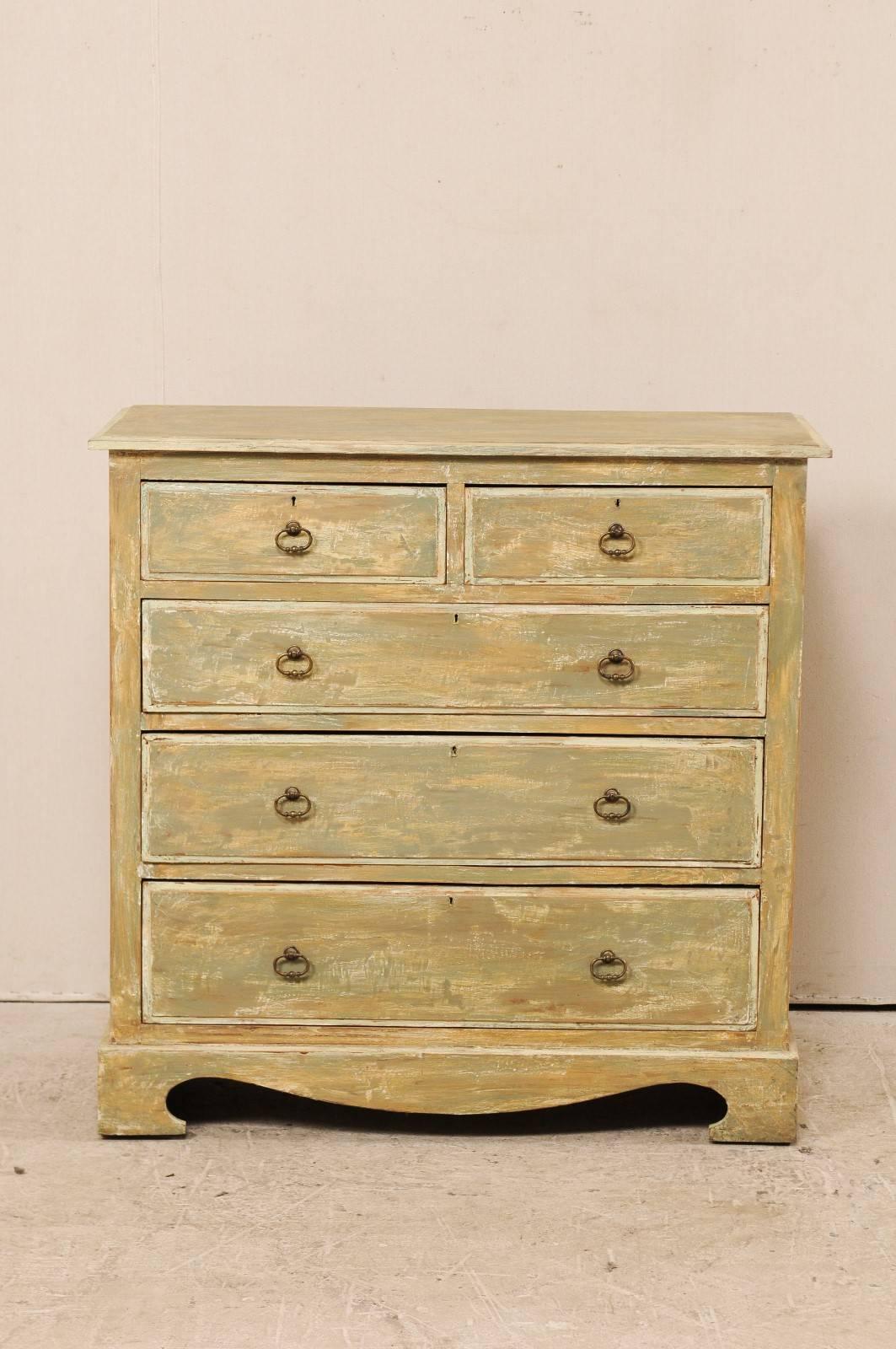 A Swedish painted wood chest from the early 20th century. This antique Swedish chest features two half-length drawers over three graduated full length drawers. This chest is minimally adorn with oval ring pulls and a swag carved skirt. This chest