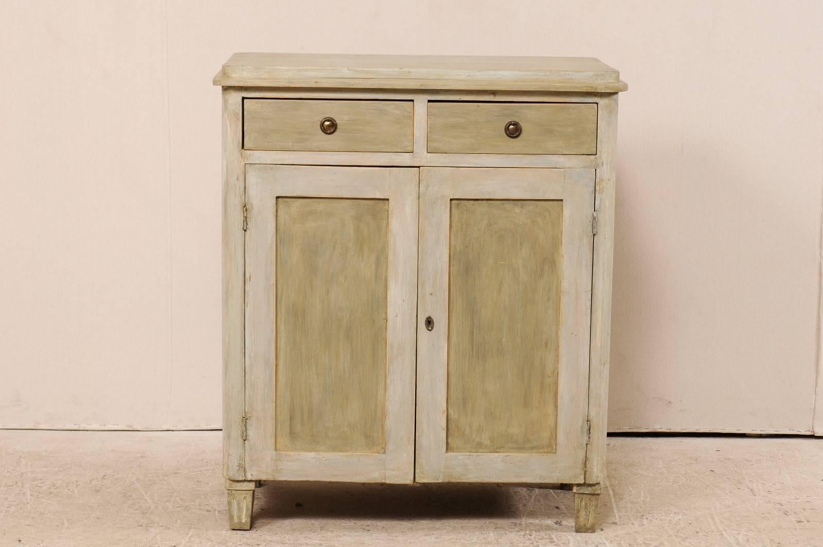 A Karl Johan Swedish cabinet from the mid-19th century. This antique Swedish painted wood side chest has been designed with nice clean lines. There are two half drawers over two doors which open to shelving on the interior. The top is raised and has