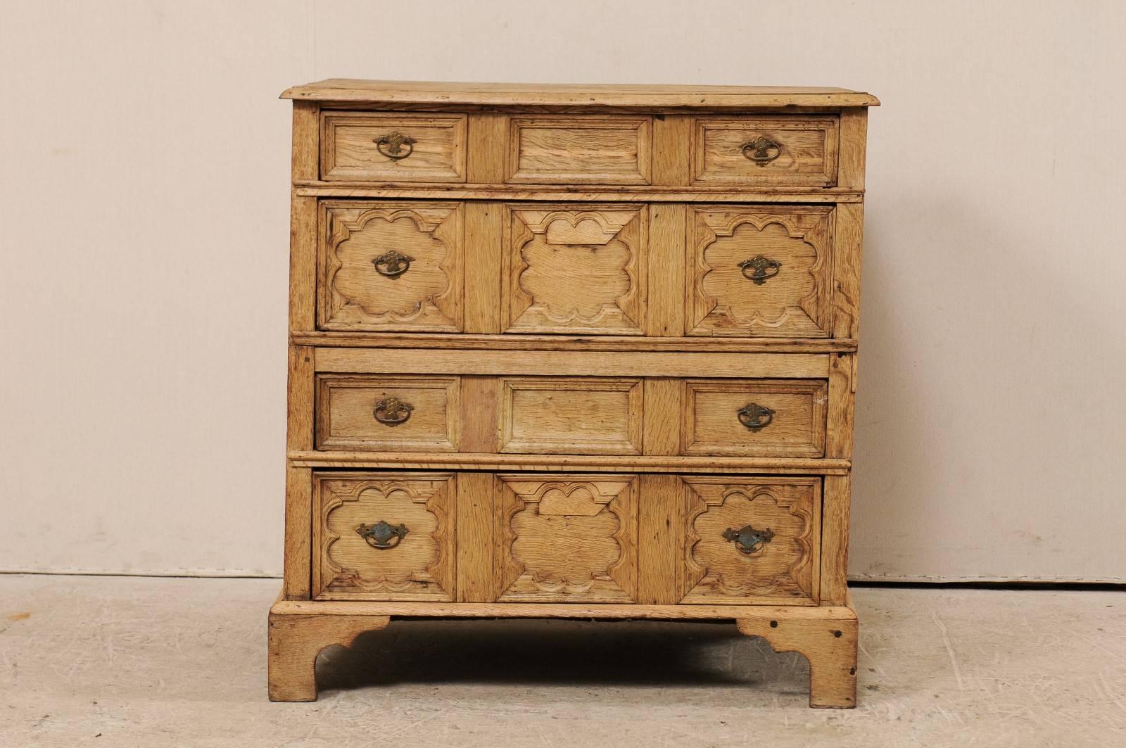 An English Jacobean chest from the 19th century. This antique Jacobean bleached wood chest features beautiful quatrefoil and rectangular carved drawer fronts. There are four dovetailed drawers, alternating between a slender top and middle drawer