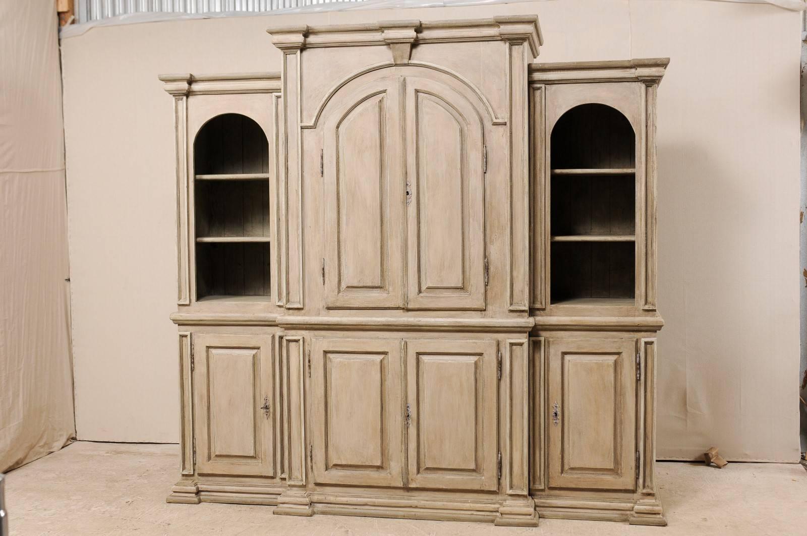 A large sized vintage Brazilian painted wood cabinet. This impressive display cabinet features a heavily molded cornice and base, and nicely arched tops framing the upper display cabinets. This cabinet has a stepped out and larger center section of