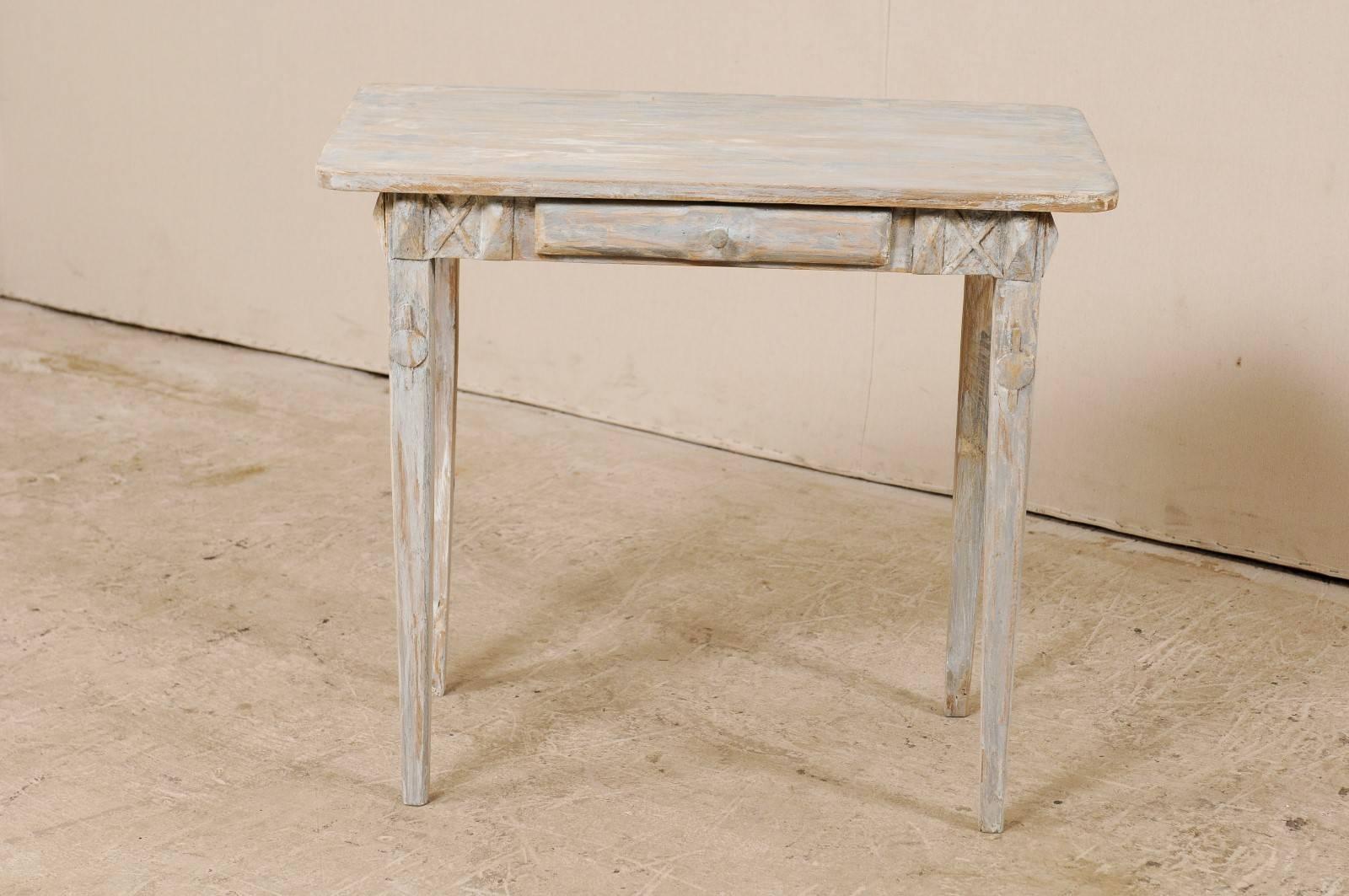 A Swedish period Gustavian, 19th century painted wood side table. This antique Swedish small sized table features nice clean lines, a rectangular-shaped top, and single drawer. The drawer is flanked with x-style carvings and has a carved wood pull