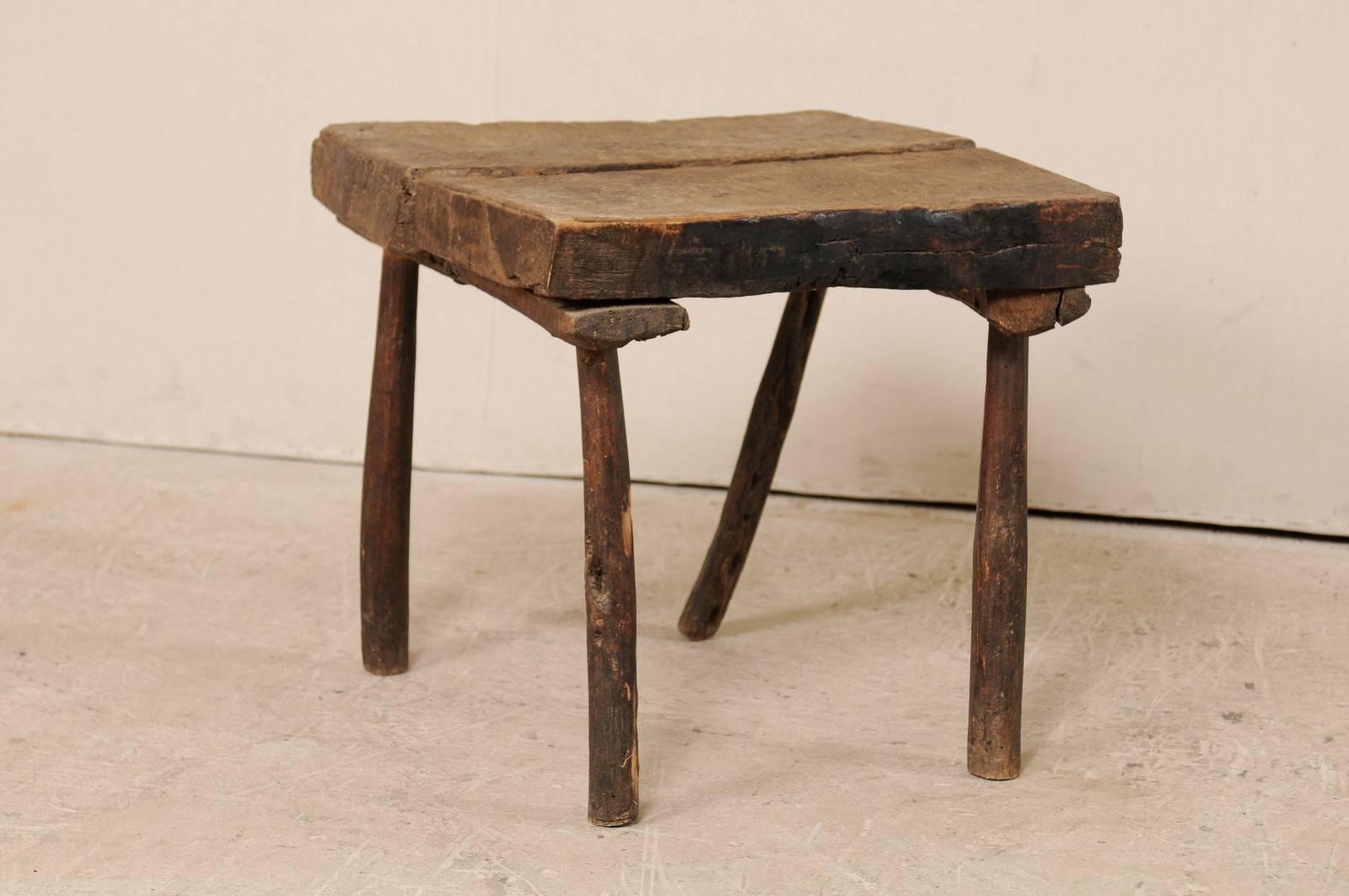 A French, 19th century side table. This rustic French side table features a thick, square-shaped top which is raised up on four twig legs. The table is oakwood, which has a nice rich earthy patina, and great show of age and its history. This