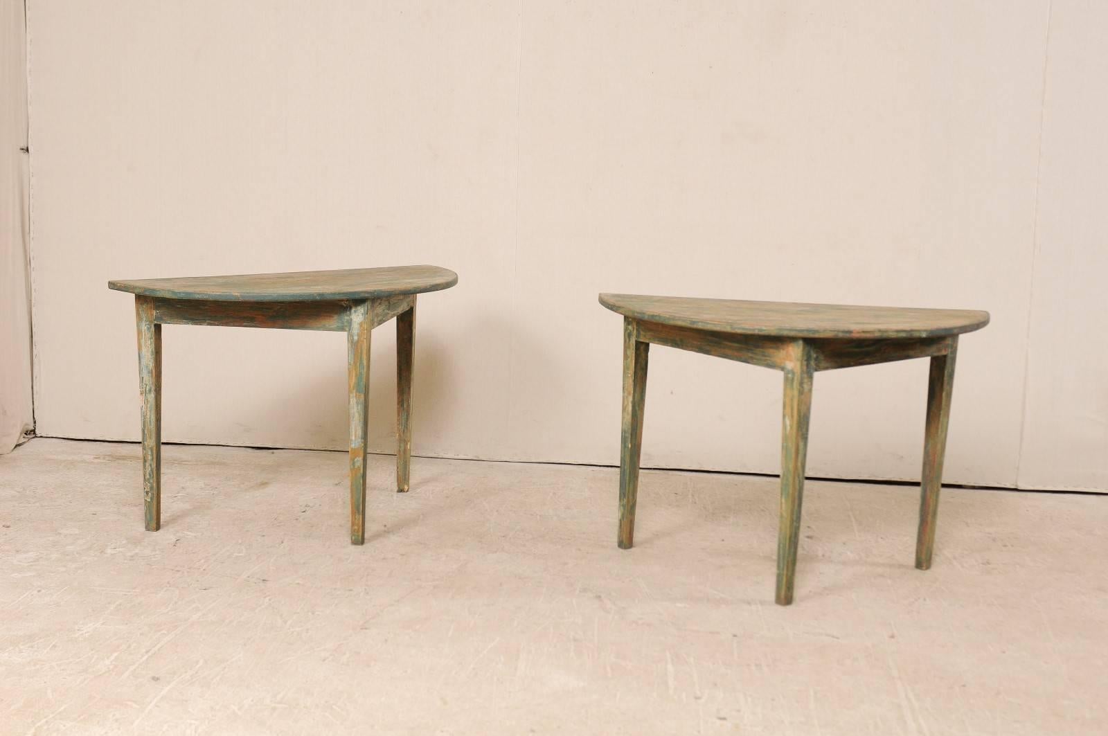 A pair of 19th century Swedish painted wood demilune tables. This pair of Swedish demilune tables from the 1880s features a semi-circular top over a triangular shaped apron. These demilune tables are each raised upon three squared and gently tapered